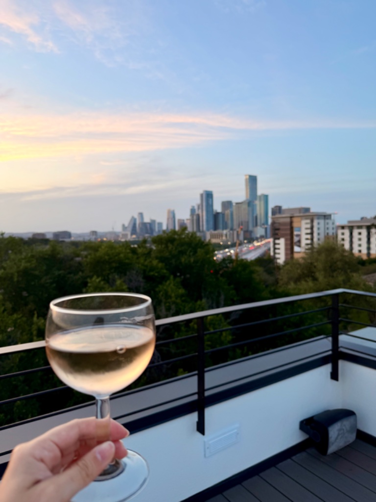Wine glass held up to Austin skyline