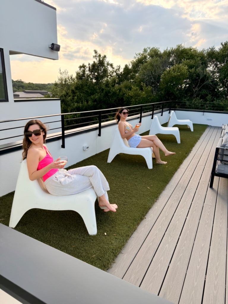 Rooftop lounge chairs on turf with skyline