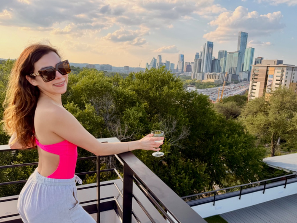 Woman enjoying wine on rooftop at golden hour