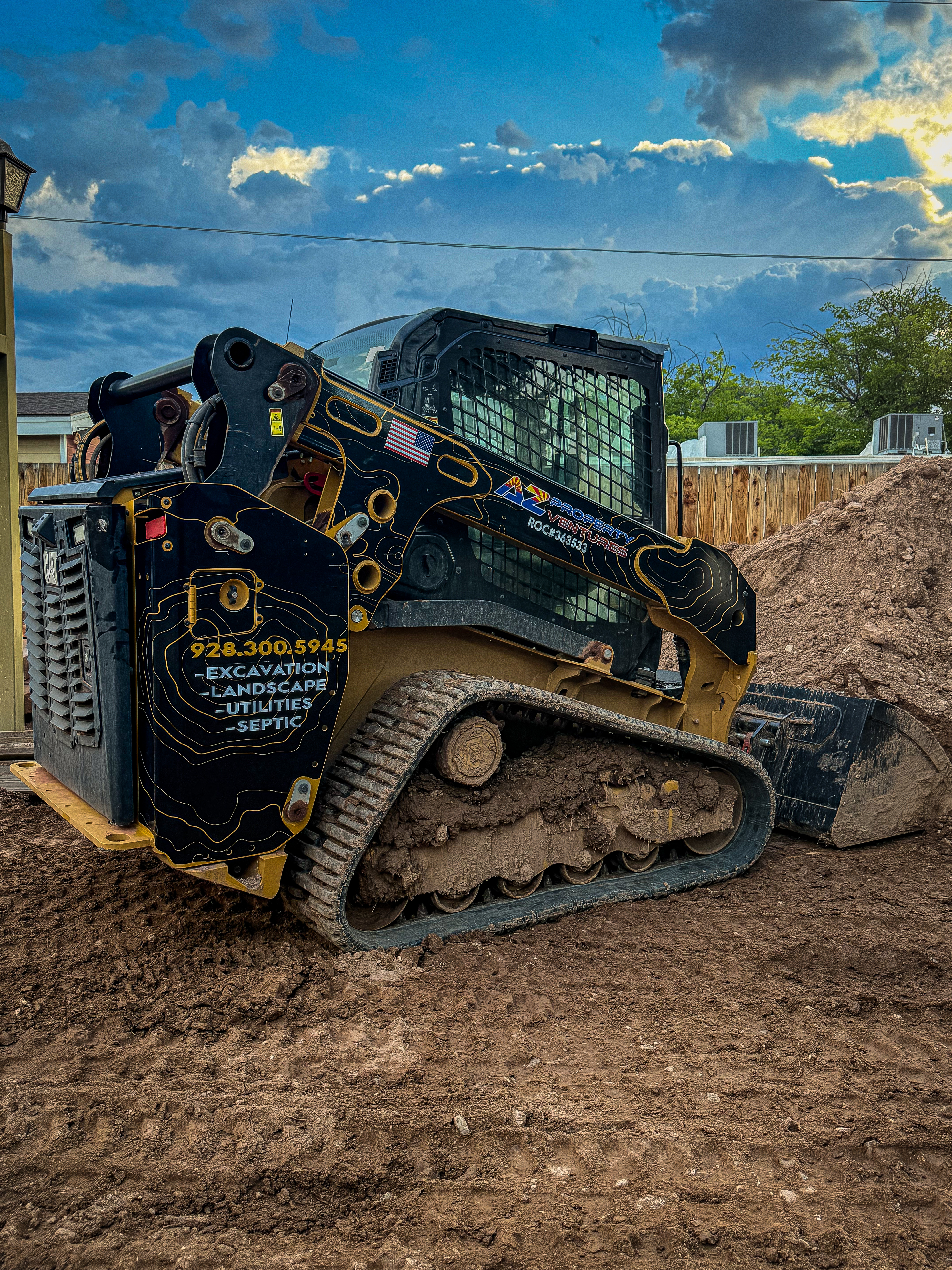 Skid Steer Wrap — AZ Property Ventures custom printed design with Caterpillar yellow topographic patterns | Cottonwood, AZ