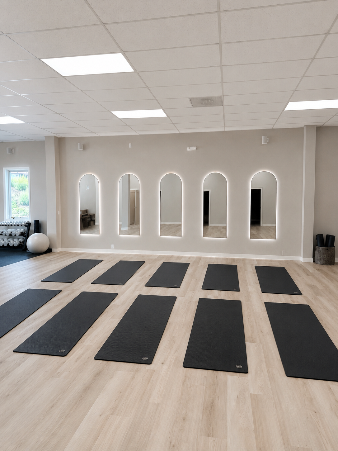 High-end fitness studio with natural light and warm wood floors
