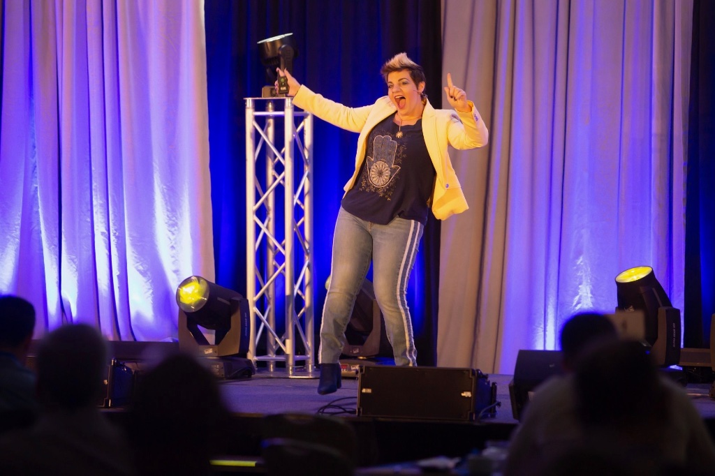 Angela speaking on stage with award