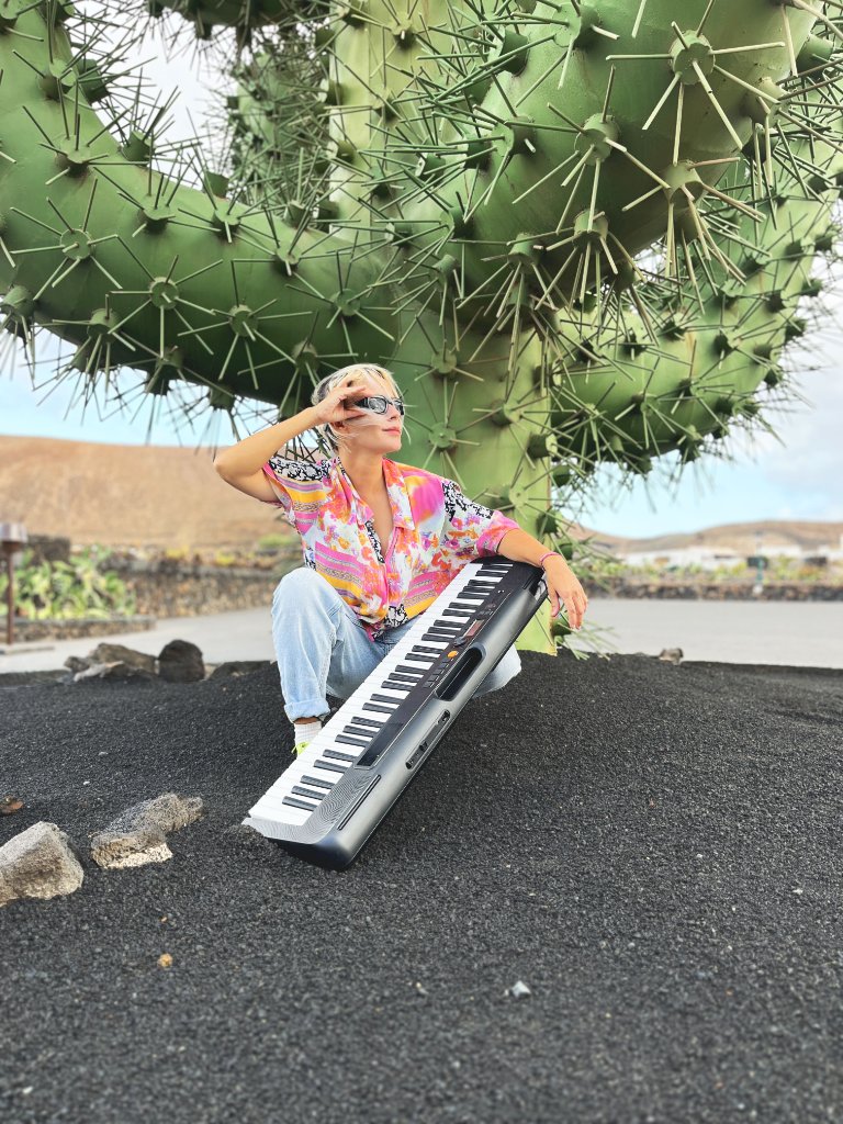 Keila Boaventura com teclado em frente a um cactus gigante