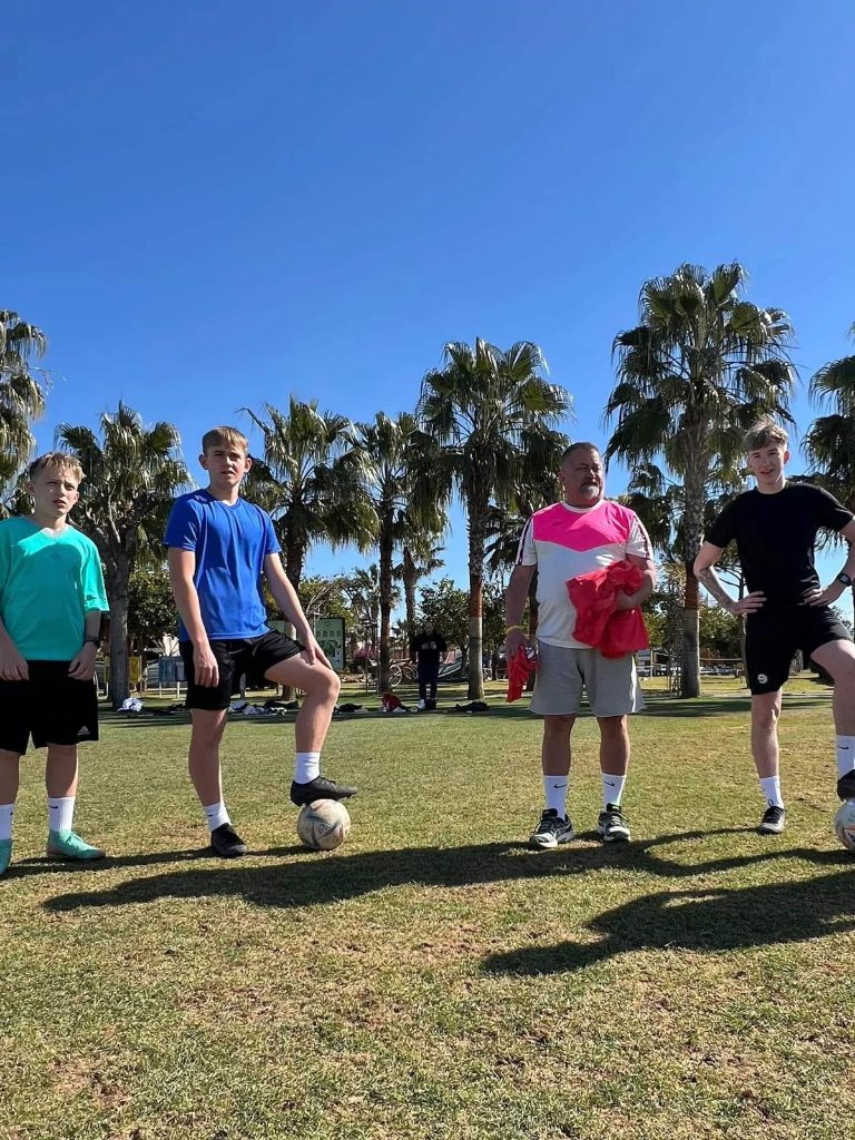 Football IQ Academy coach with players among palms – international football camp