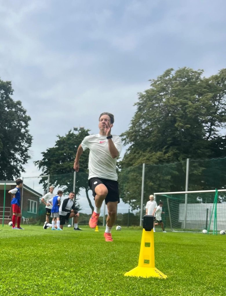 Football IQ Academy coach leading sprint drill at youth football camp