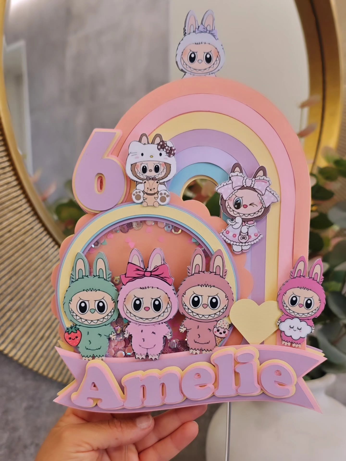 A pastel rainbow with bunny monsters and a glitter shaker for Amelie's 6th.