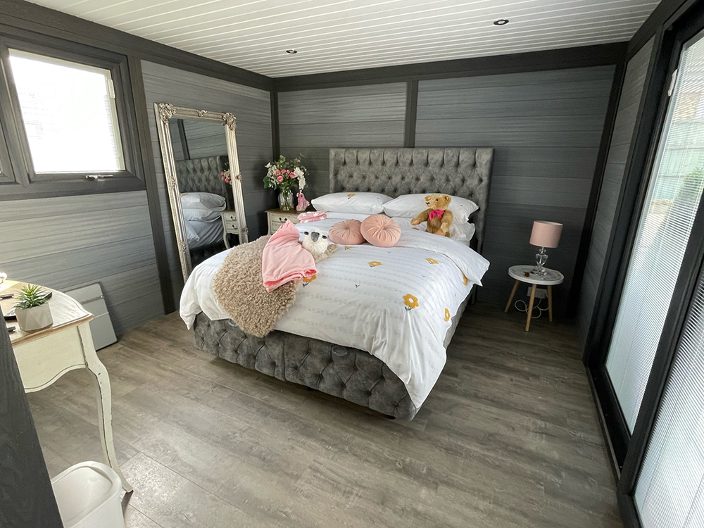 Annexe bedroom with upholstered bed and sliding doors