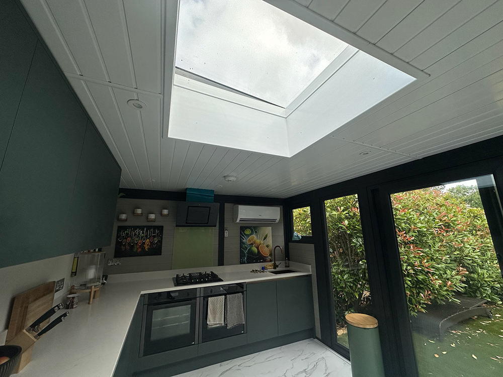 Annexe kitchen with teal units and skylight