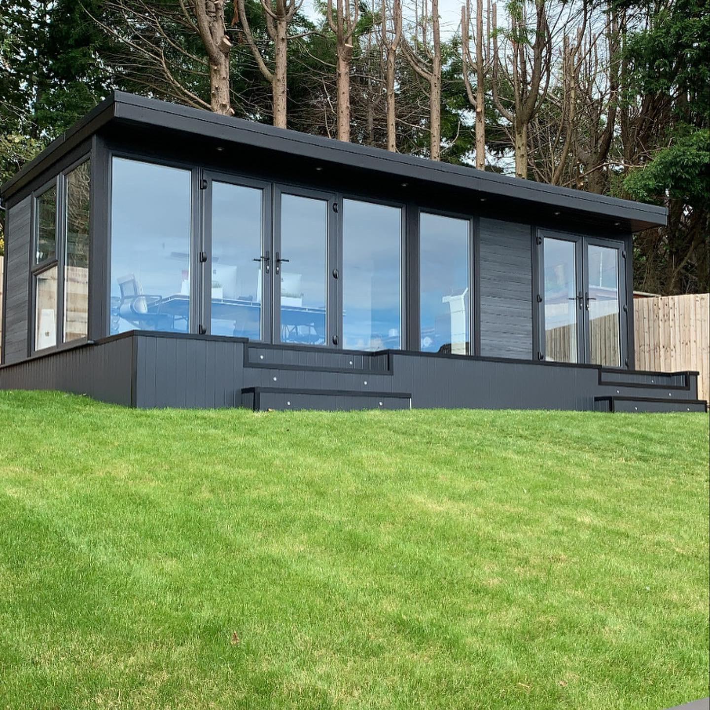 Three-sided glass garden room with bi-fold doors open