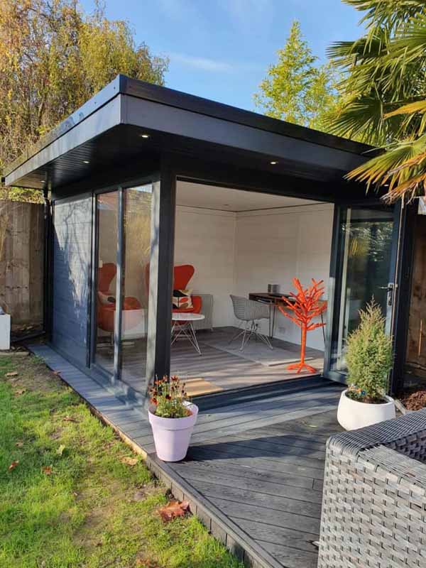 Composite garden studio with open bi-fold doors and deck