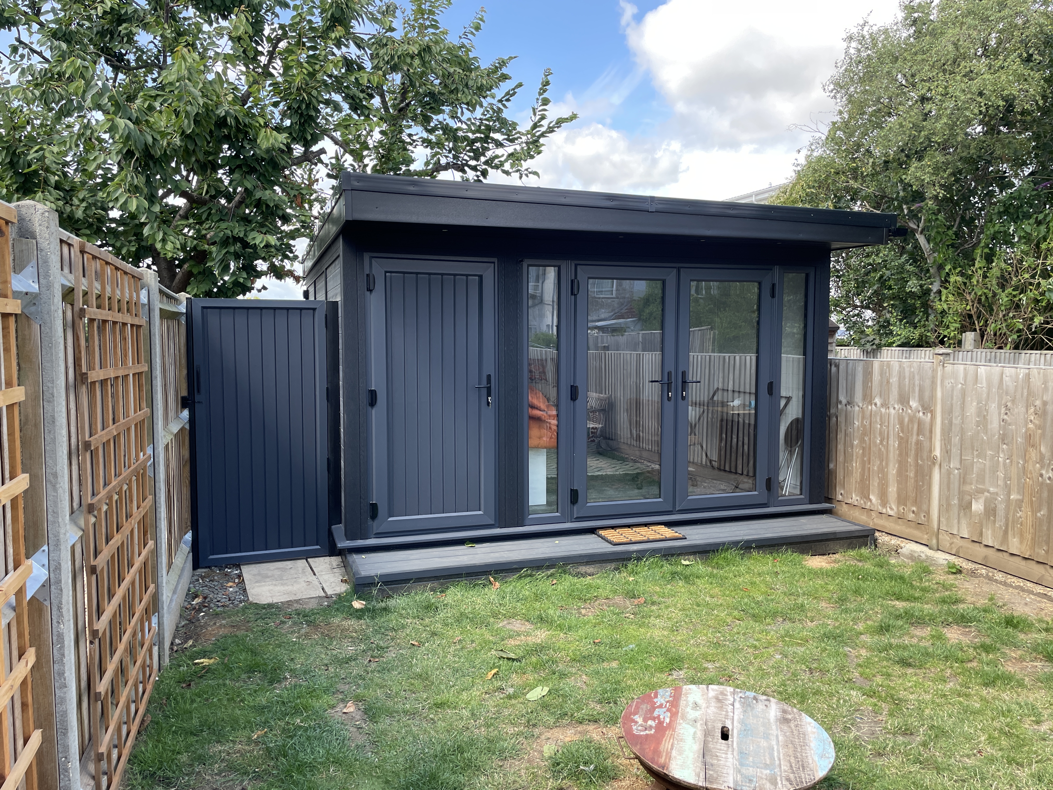 Charcoal-grey garden room with integrated storage and double doors