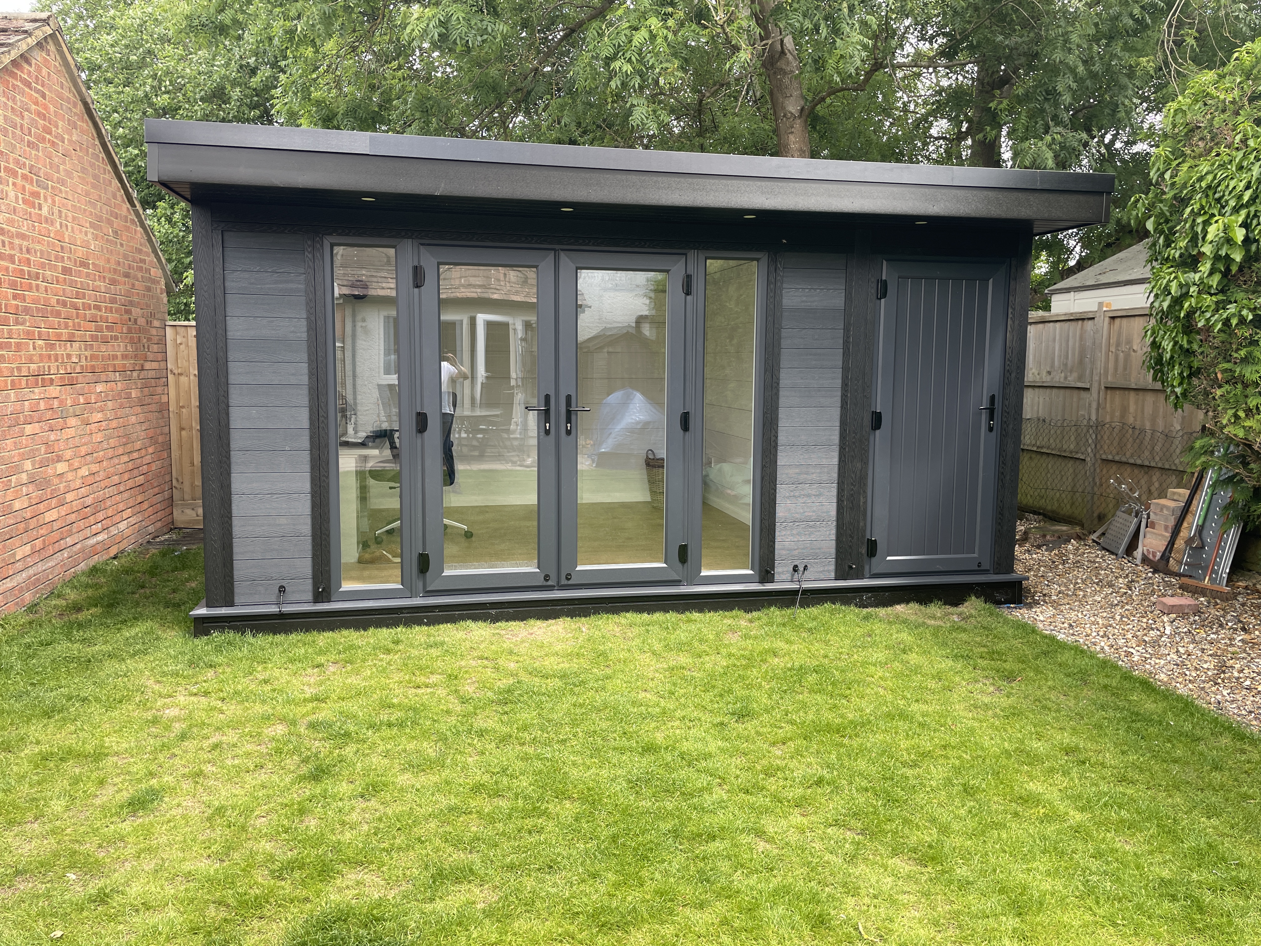 Completed garden room exterior with grey cladding and glass doors