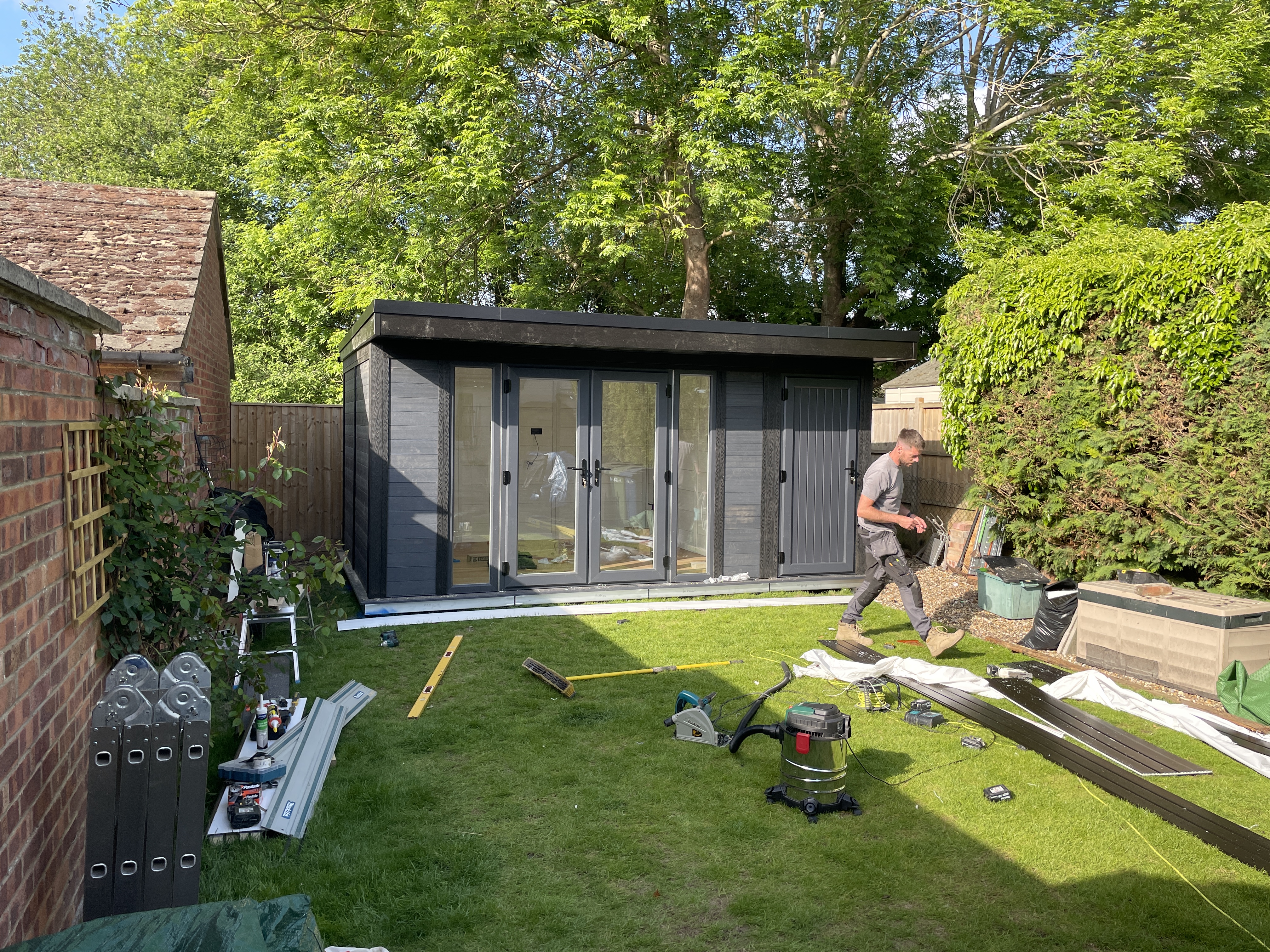 Garden Rooms Online team member on site during construction of a dark grey garden room