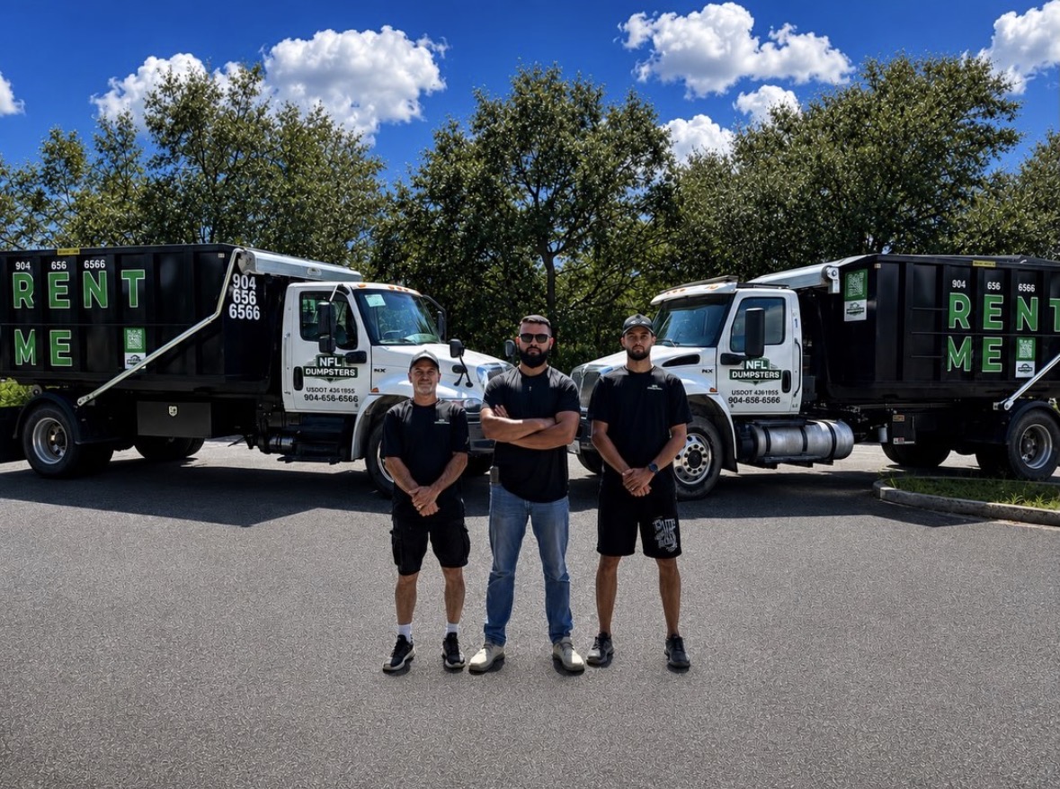 The NFL Dumpsters team standing in front of their black dump trucks