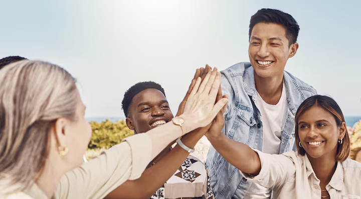 Diverse team of young adults doing a group high-five