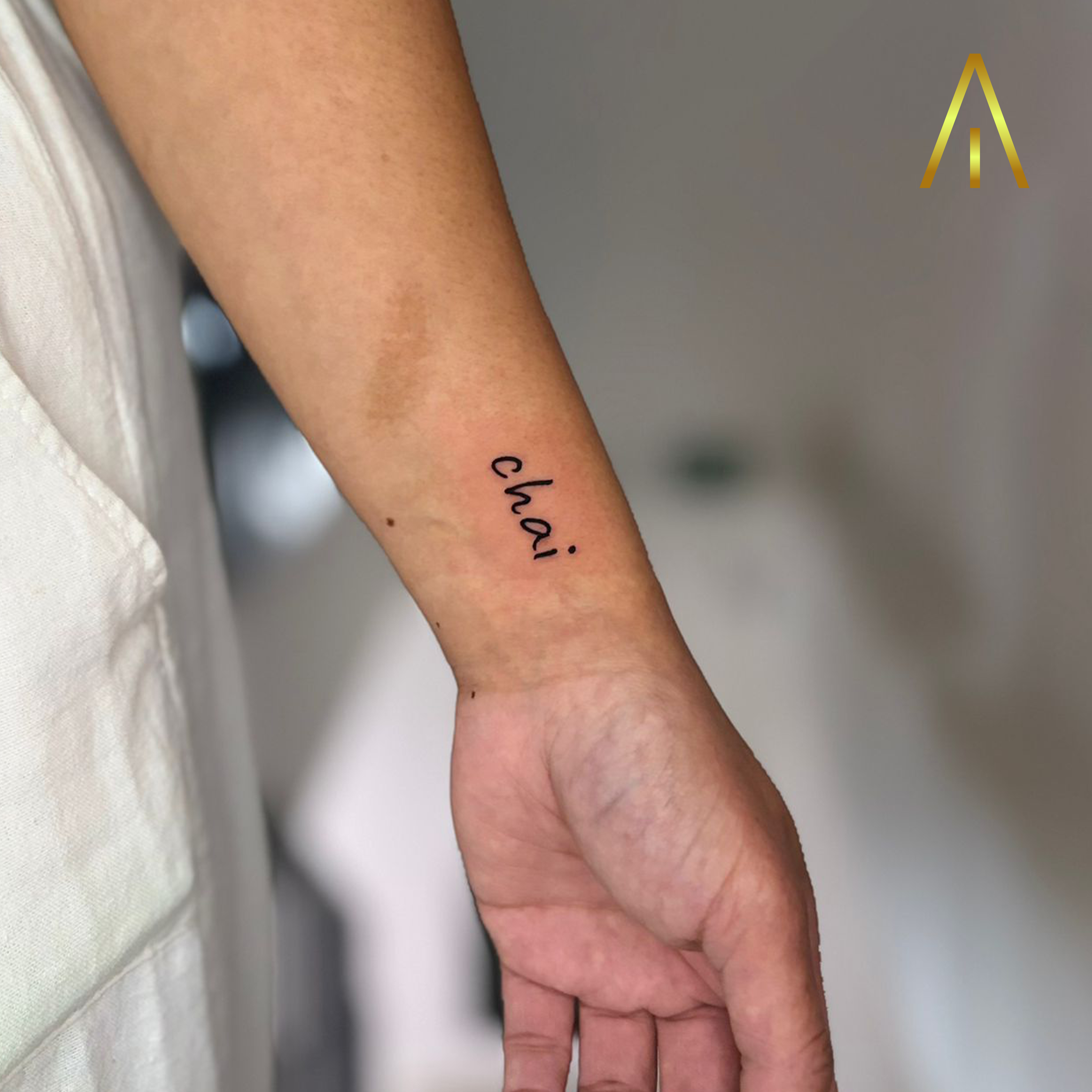 Fine line chai cursive script wrist tattoo Chiang Mai