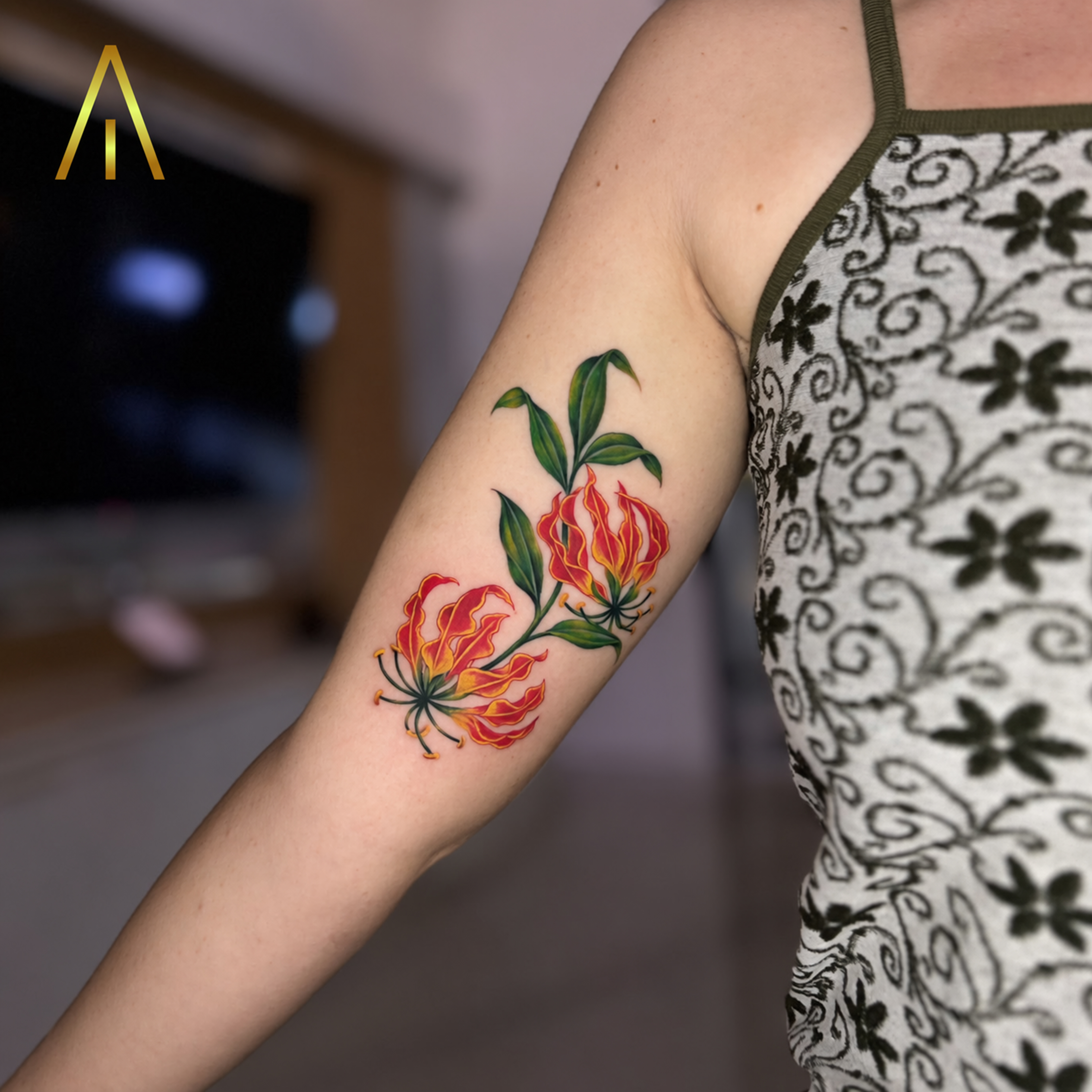 Katie Gloriosa flame lily red and yellow colour upper arm tattoo Chiang Mai