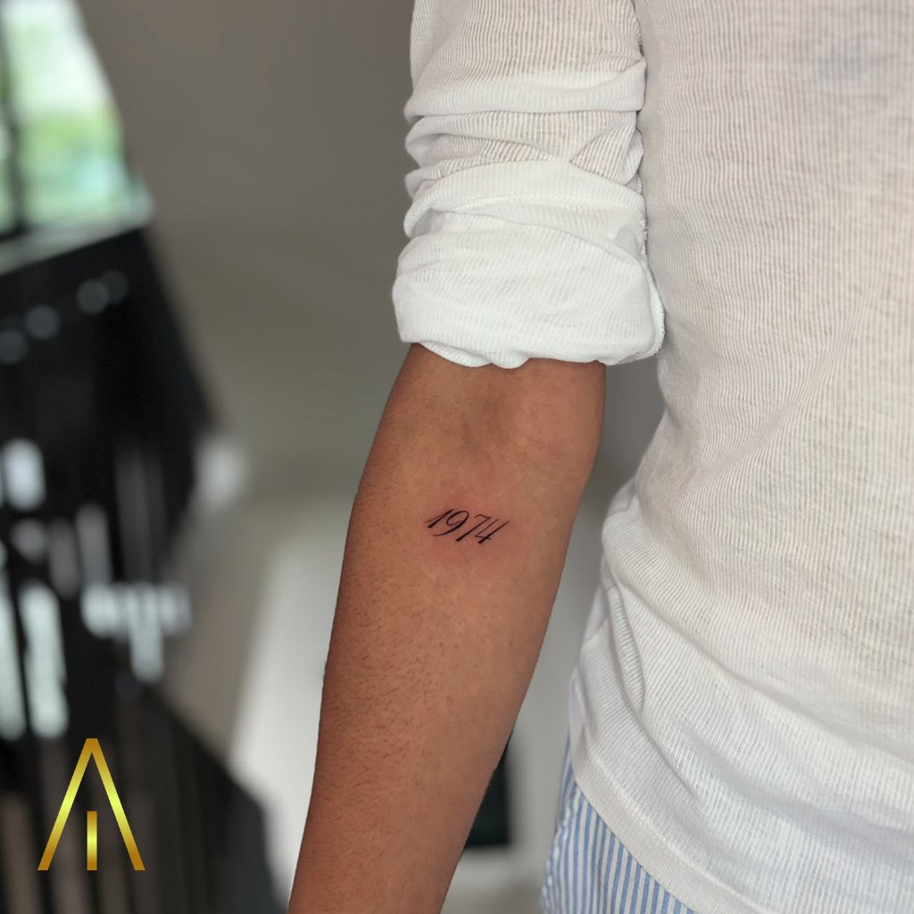 Fine line 1974 script tattoo on forearm Chiang Mai
