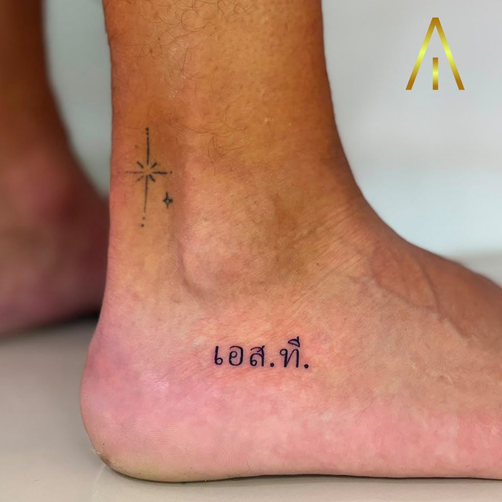 Fine line star and Thai script tattoo on ankle Chiang Mai