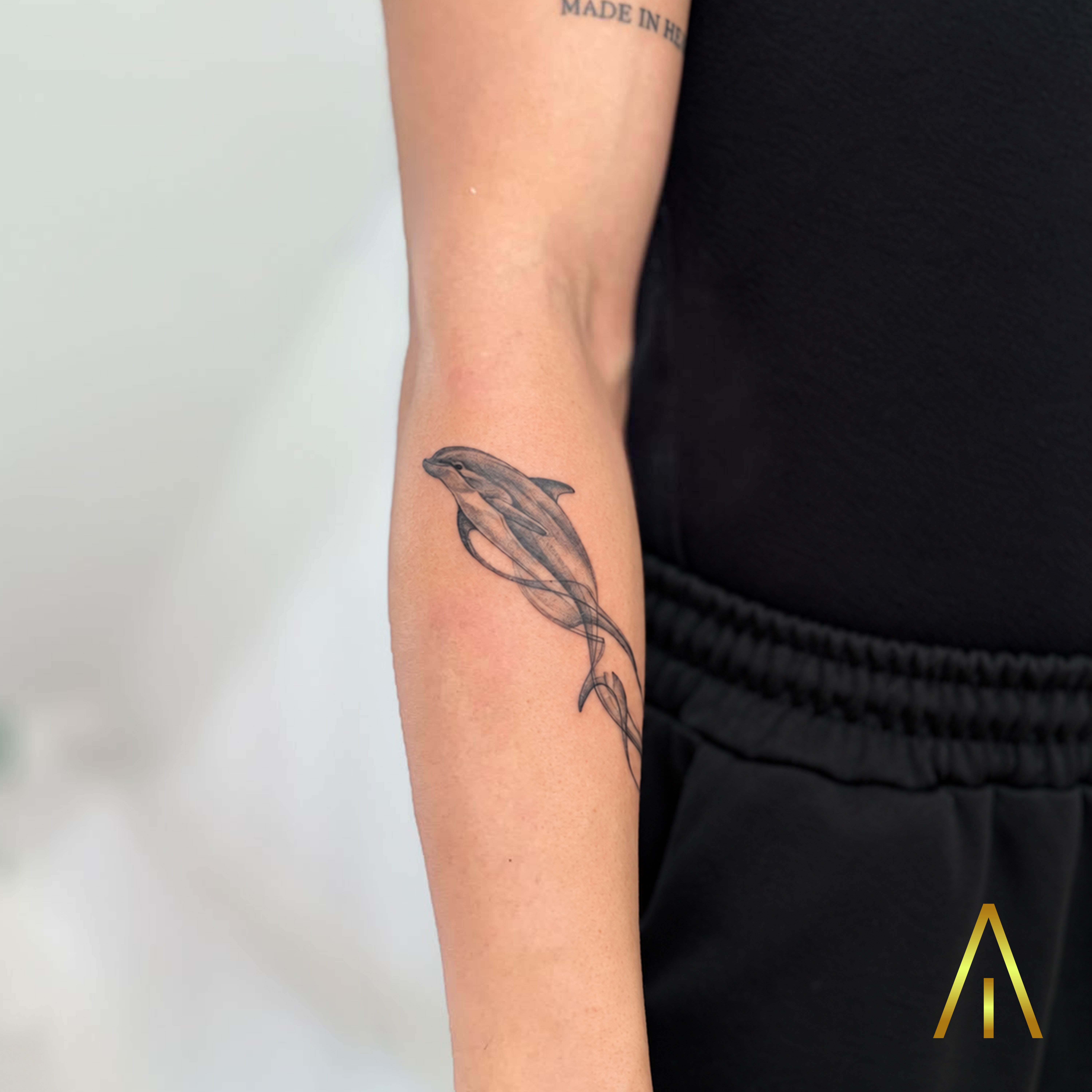Mimi dolphin swimming fine line minimal forearm tattoo Chiang Mai