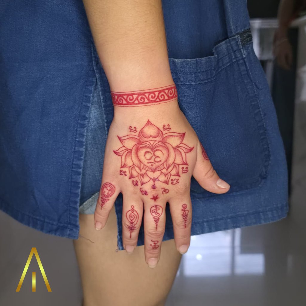 Sak Yant red ink lotus Om tattoo on hand Chiang Mai