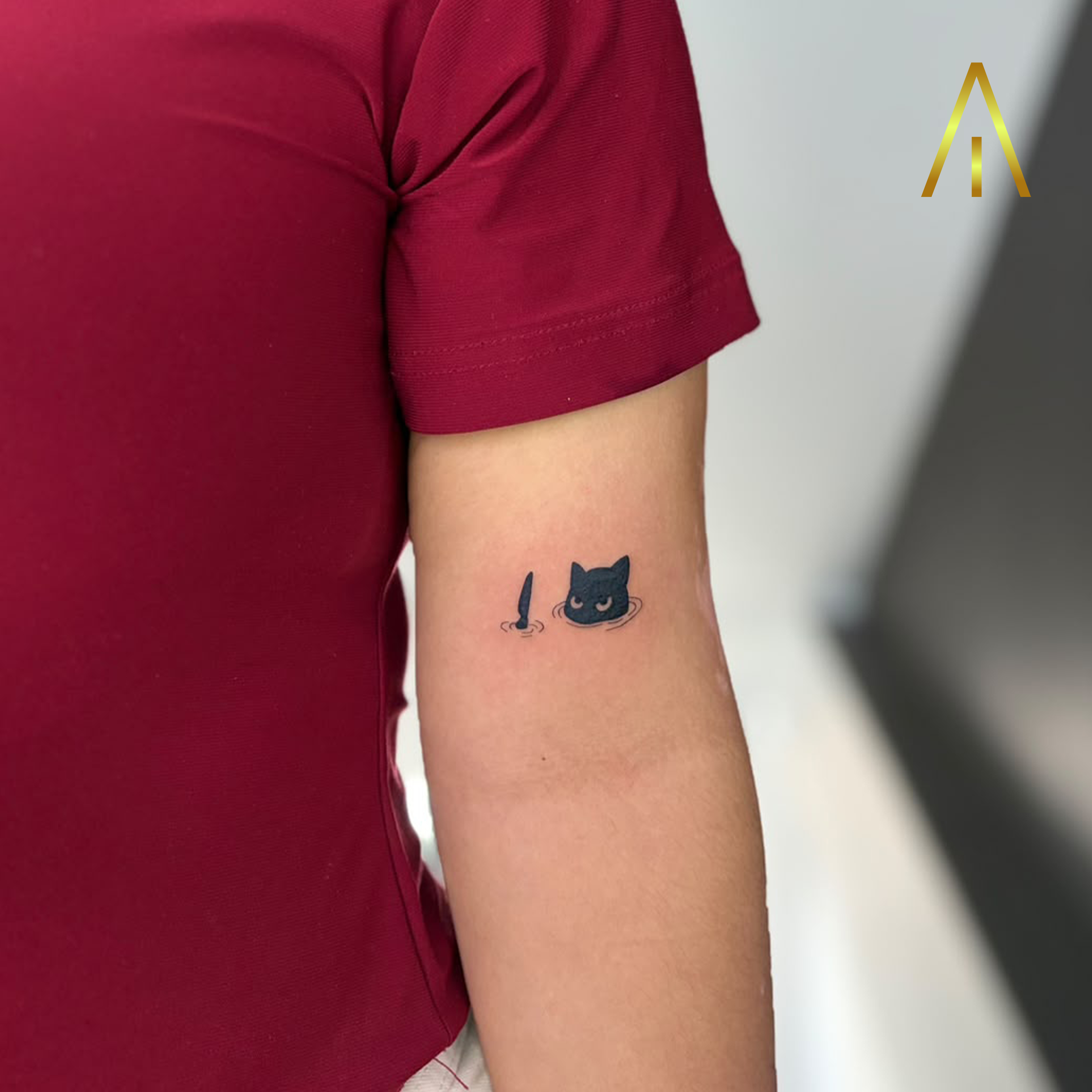 Miaa minimal black cat in water upper arm tattoo Chiang Mai