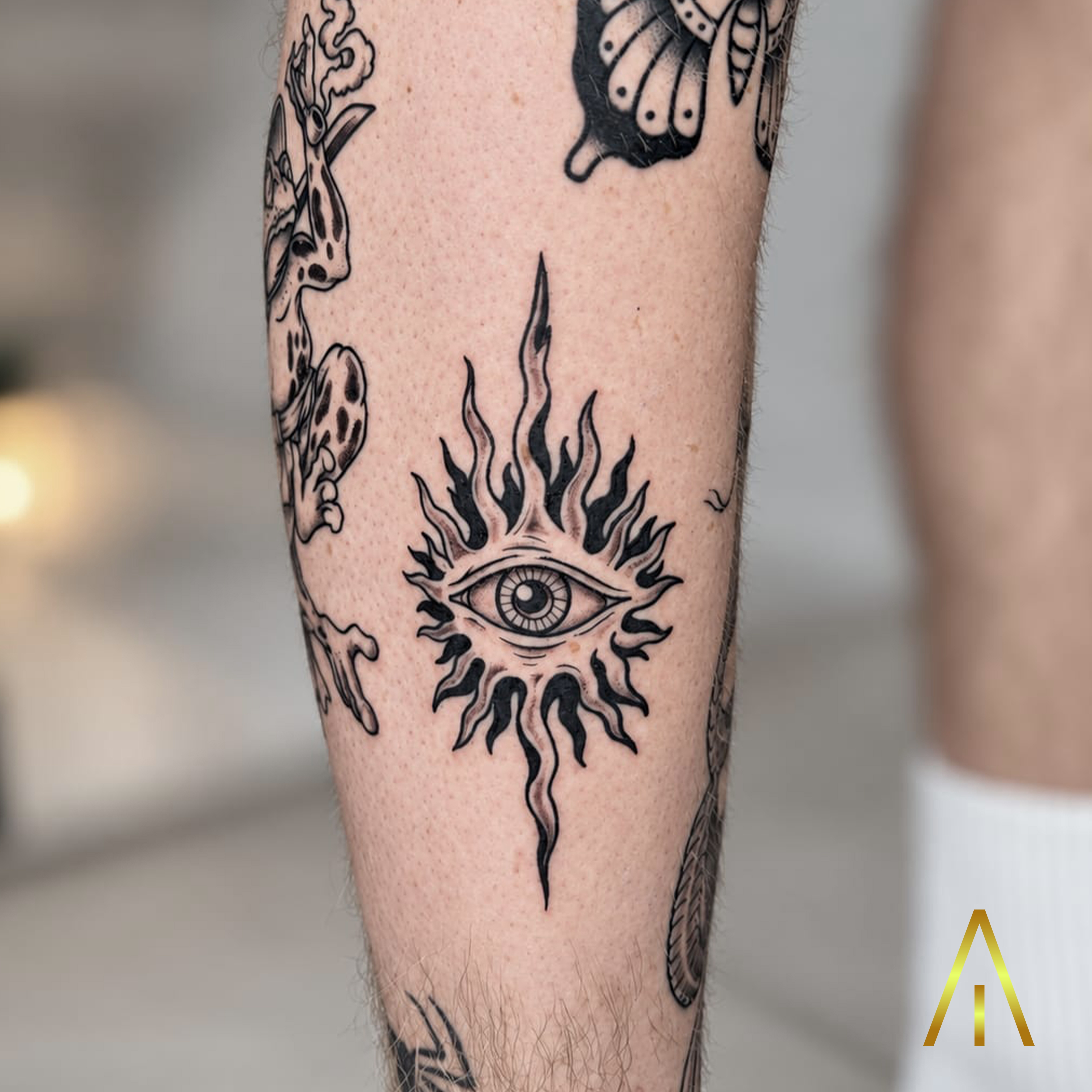 Katie all-seeing eye radiating flames minimal calf tattoo Chiang Mai
