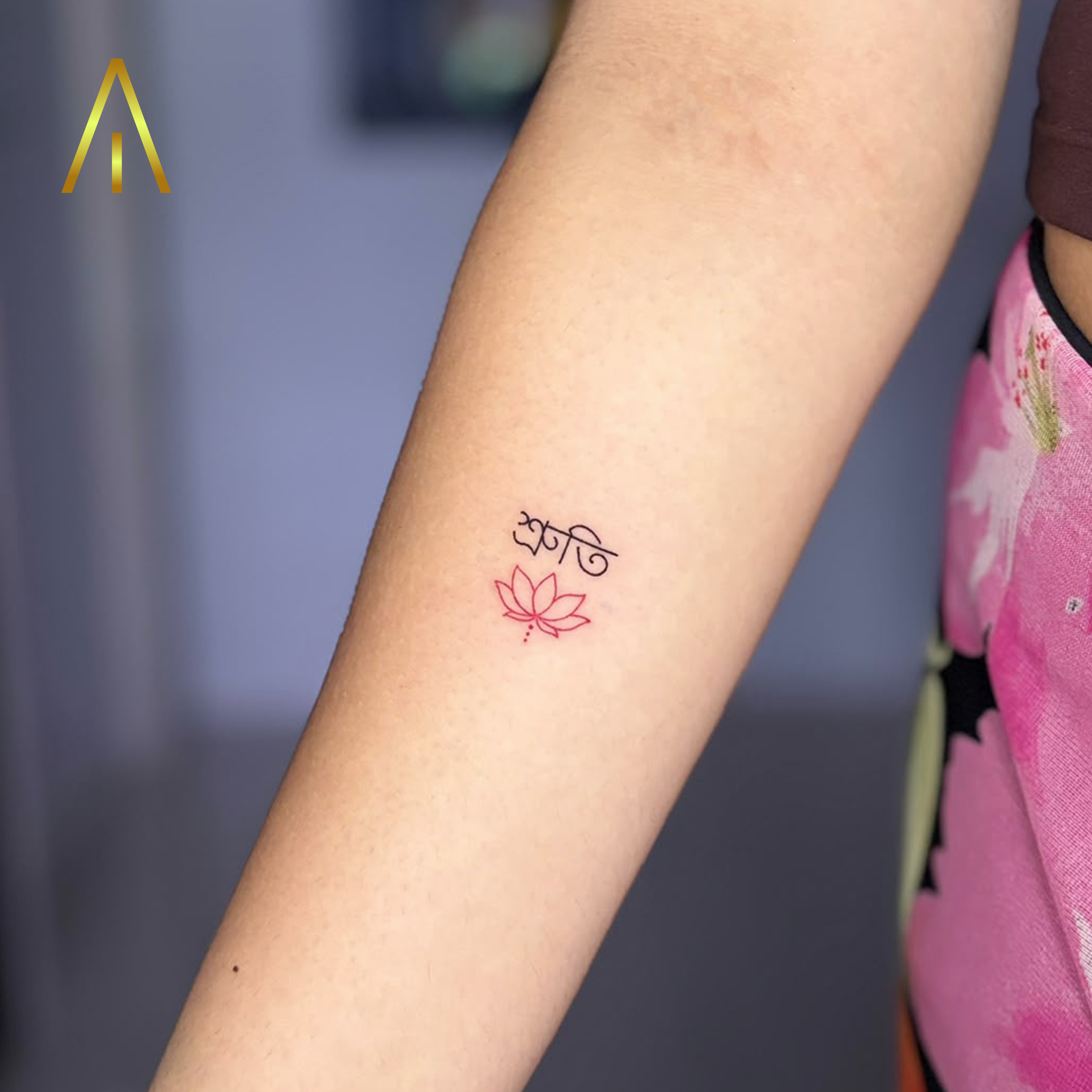 Mimi fine line Bengali script with red lotus forearm tattoo Chiang Mai