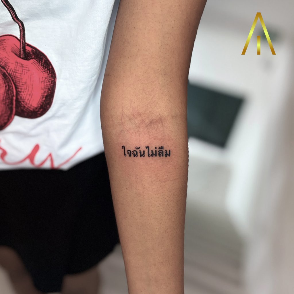 Fine line Thai script text tattoo on forearm Chiang Mai
