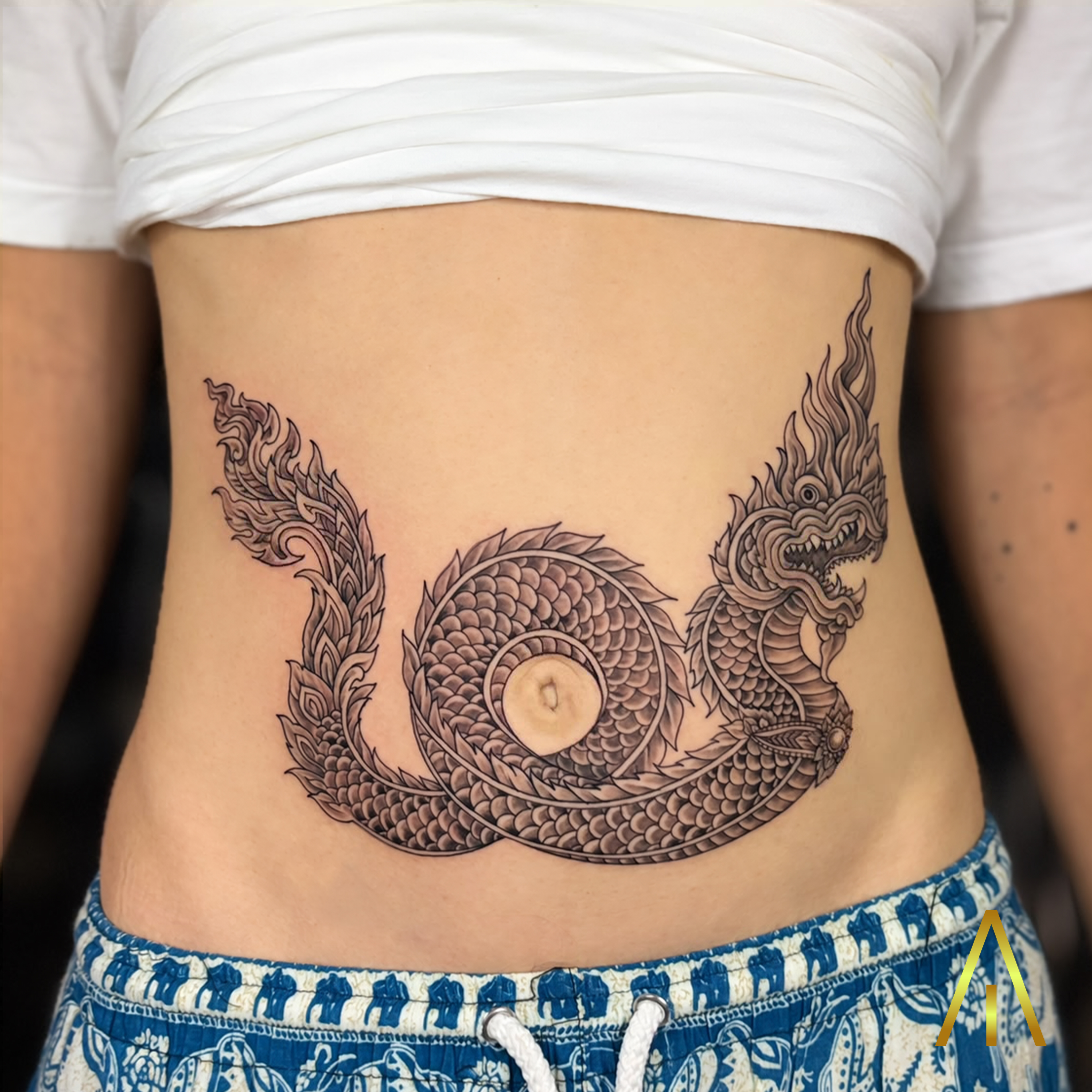 Taely Naga serpent coiled black and grey abdomen tattoo Chiang Mai