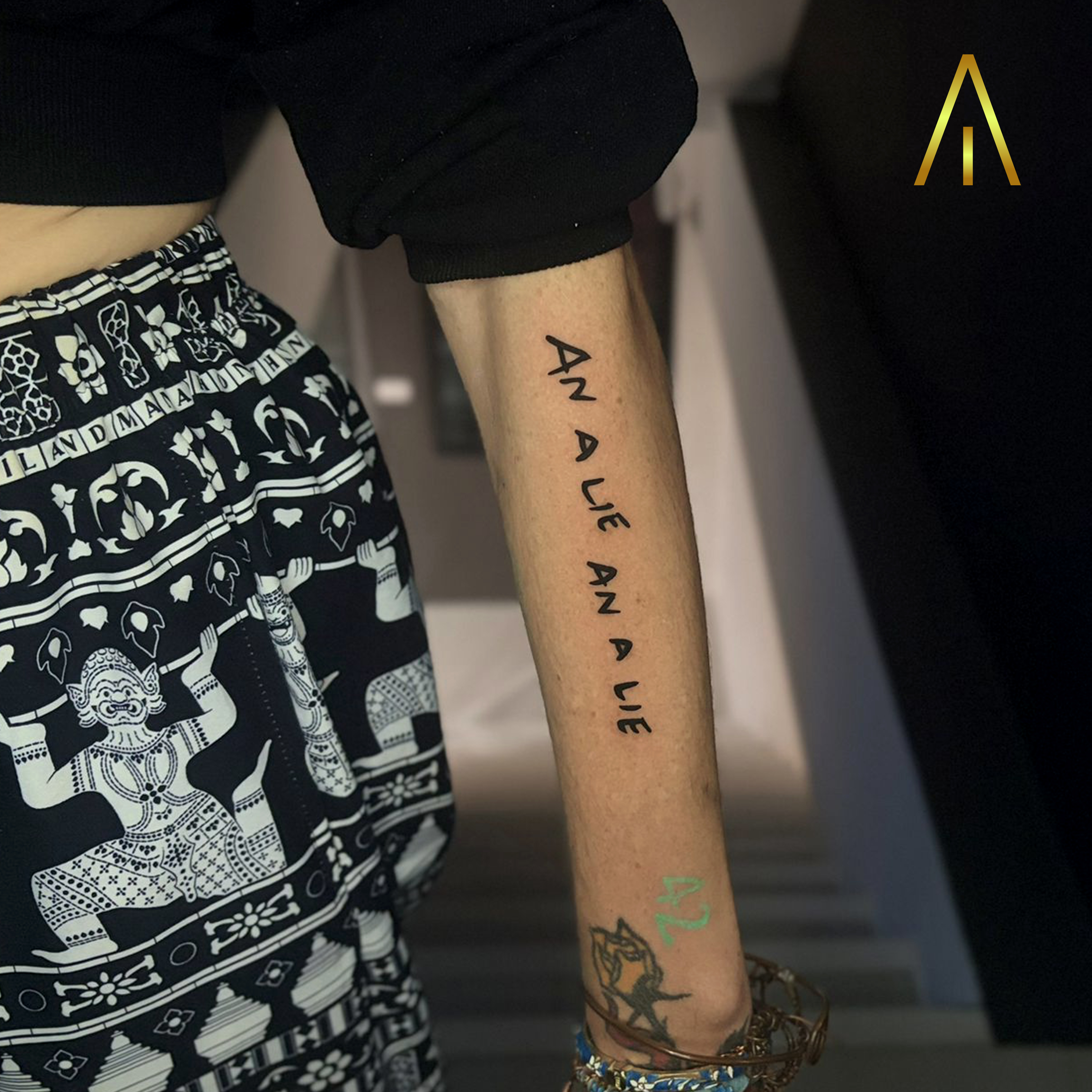 Blackwork AN A LIE script forearm tattoo Chiang Mai