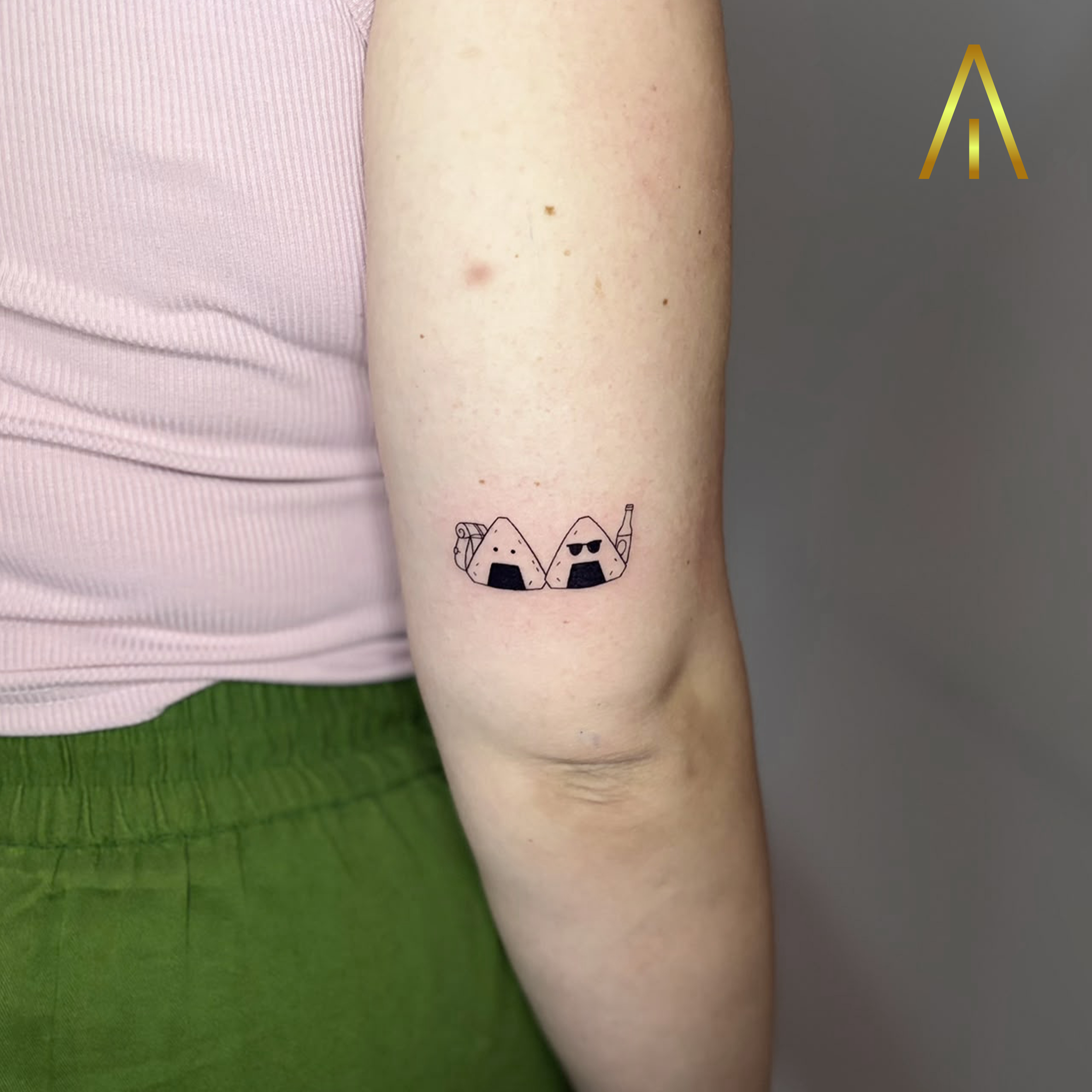 Mimi two onigiri characters with backpack and sunglasses upper arm tattoo Chiang Mai