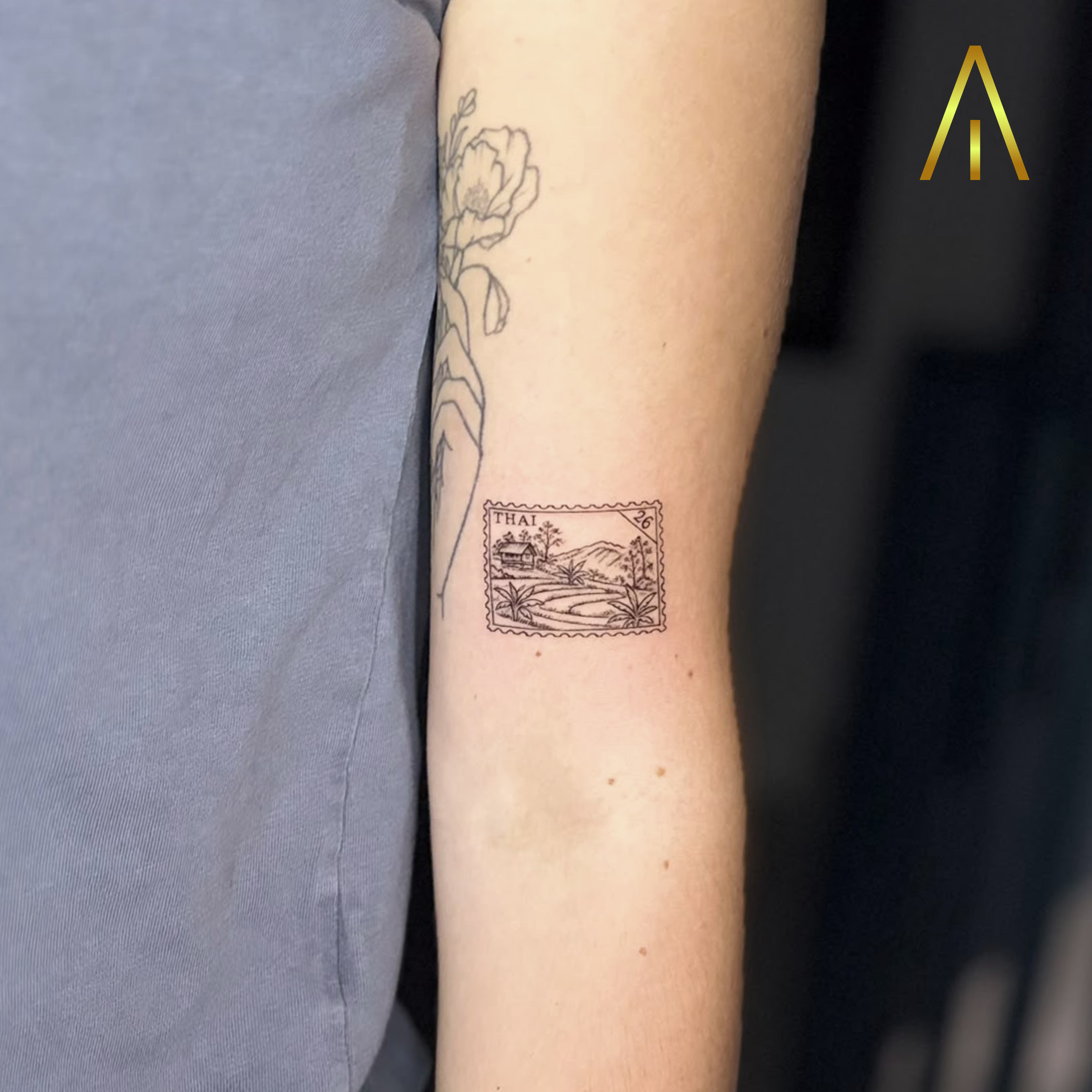 Mimi fine line Thai landscape postage stamp upper arm tattoo Chiang Mai