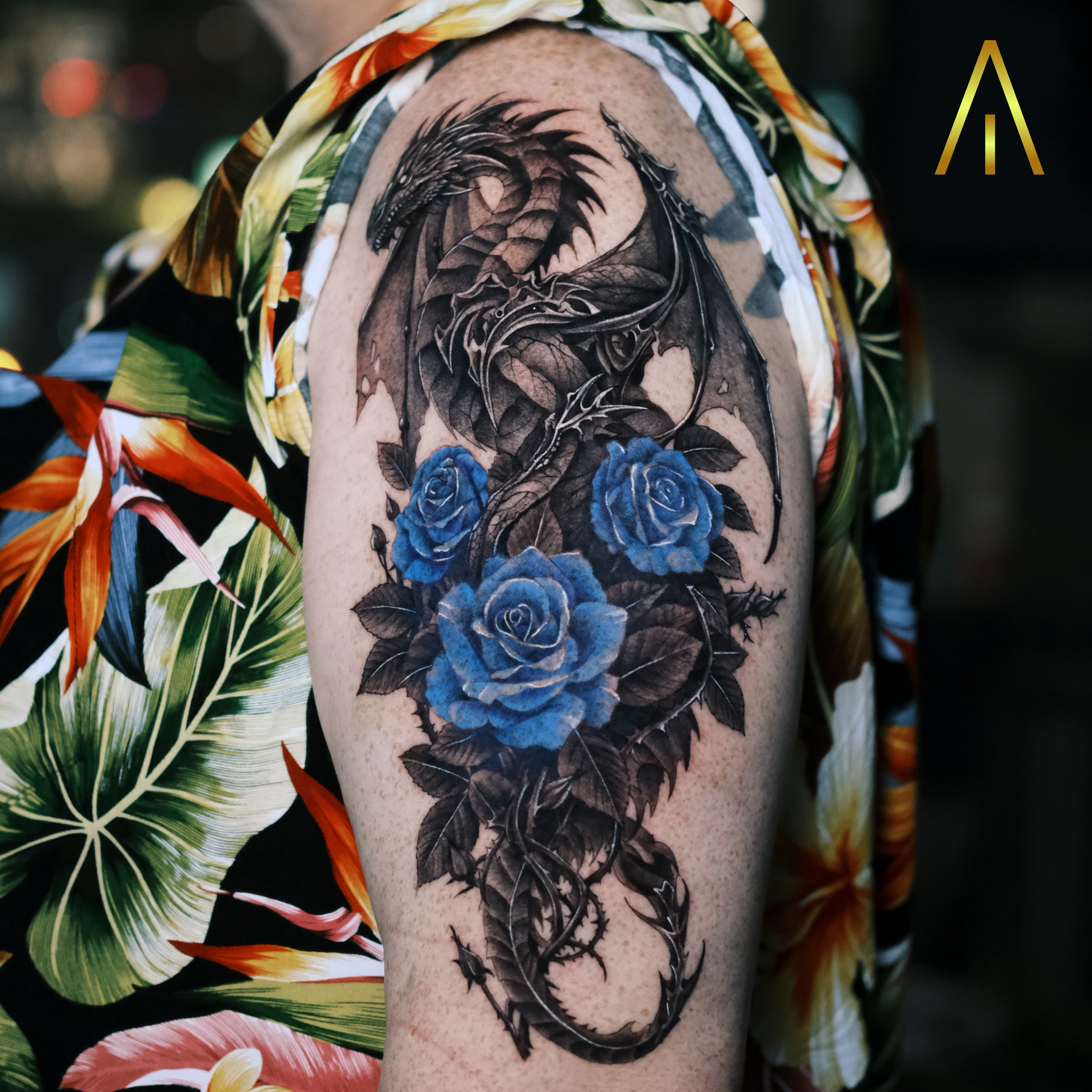 Katie black and grey dragon with blue roses upper arm tattoo Chiang Mai