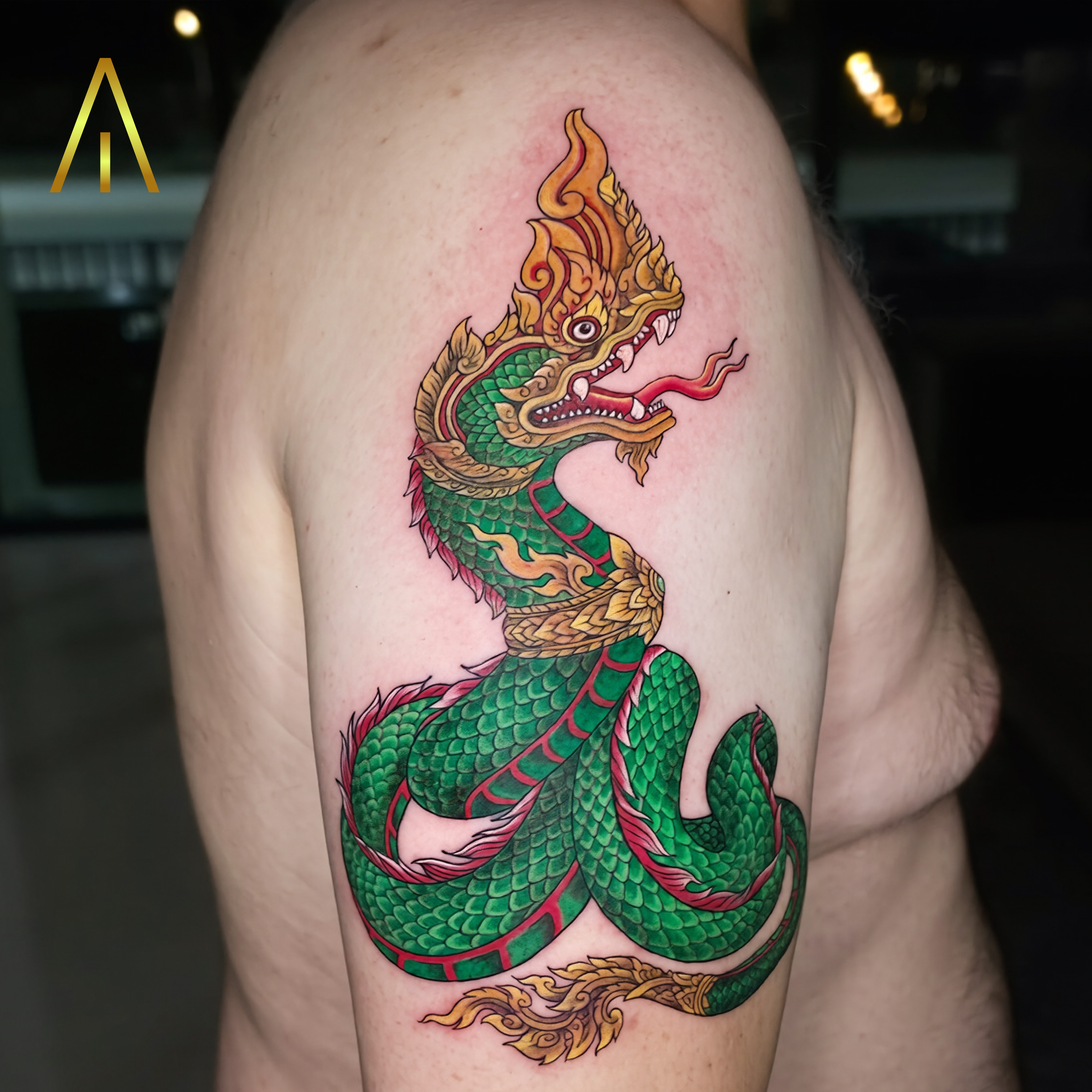 Taely colour Thai Naga serpent upper arm tattoo Chiang Mai