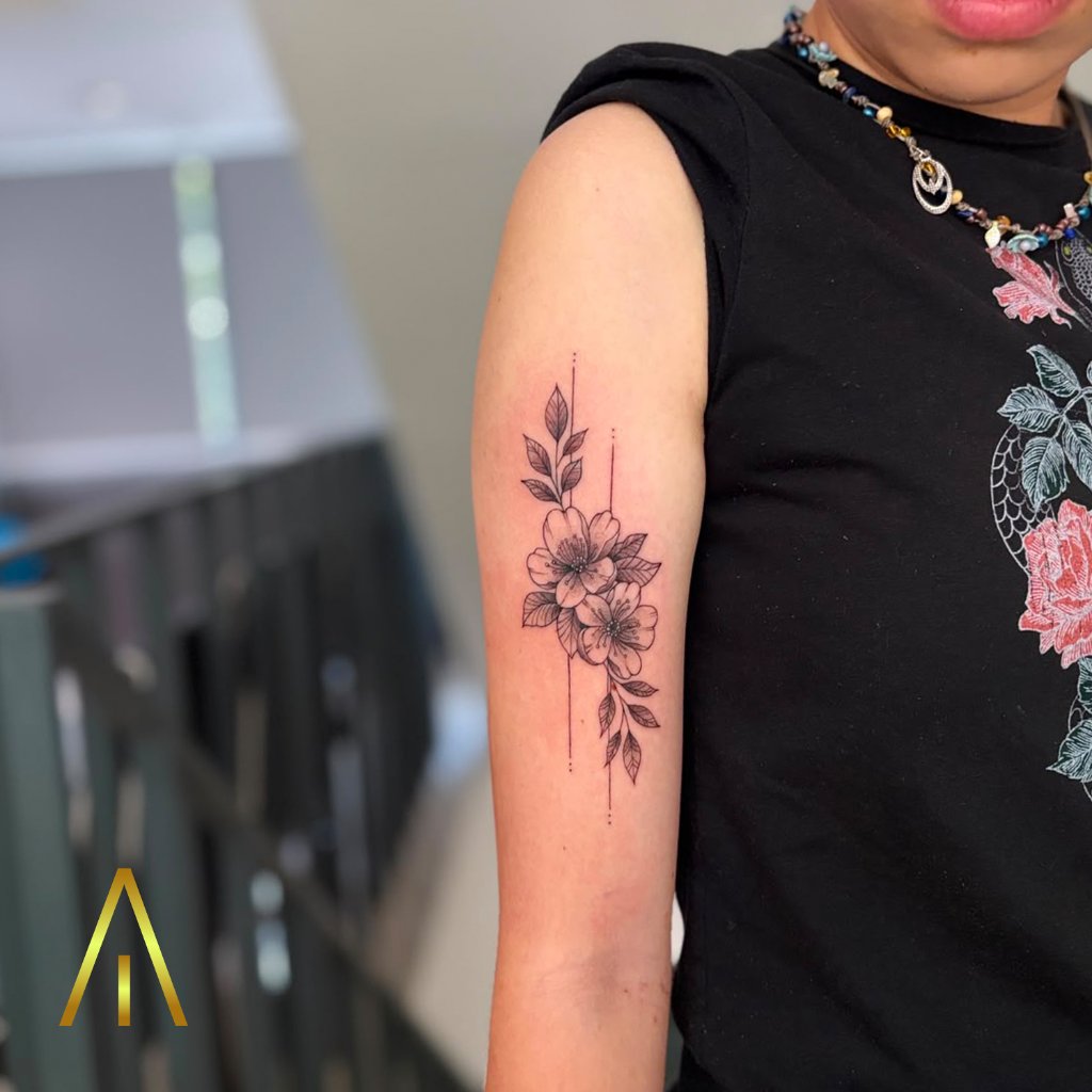 Minimal floral blossoms fine line tattoo on upper arm Chiang Mai