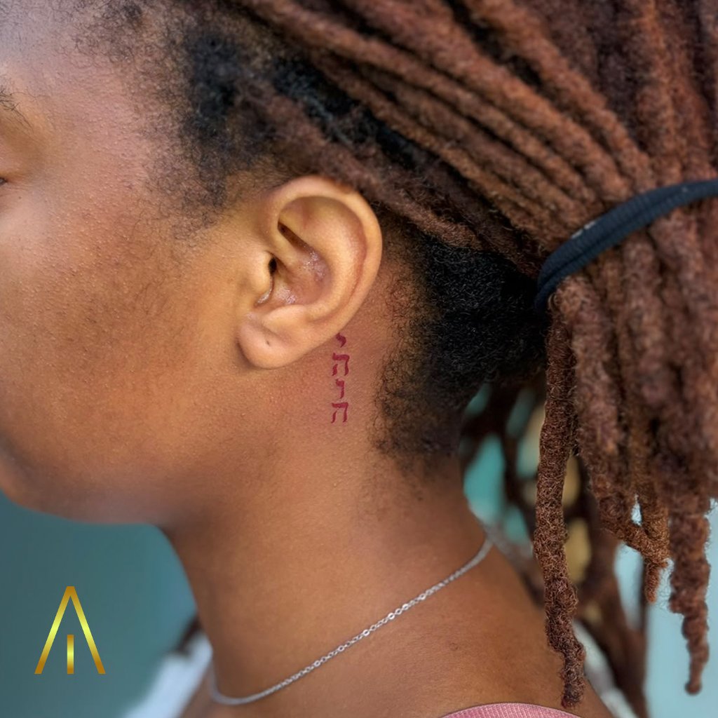 Fine line Hebrew script tattoo behind the ear by Miaa, Artisan Ink Chiang Mai
