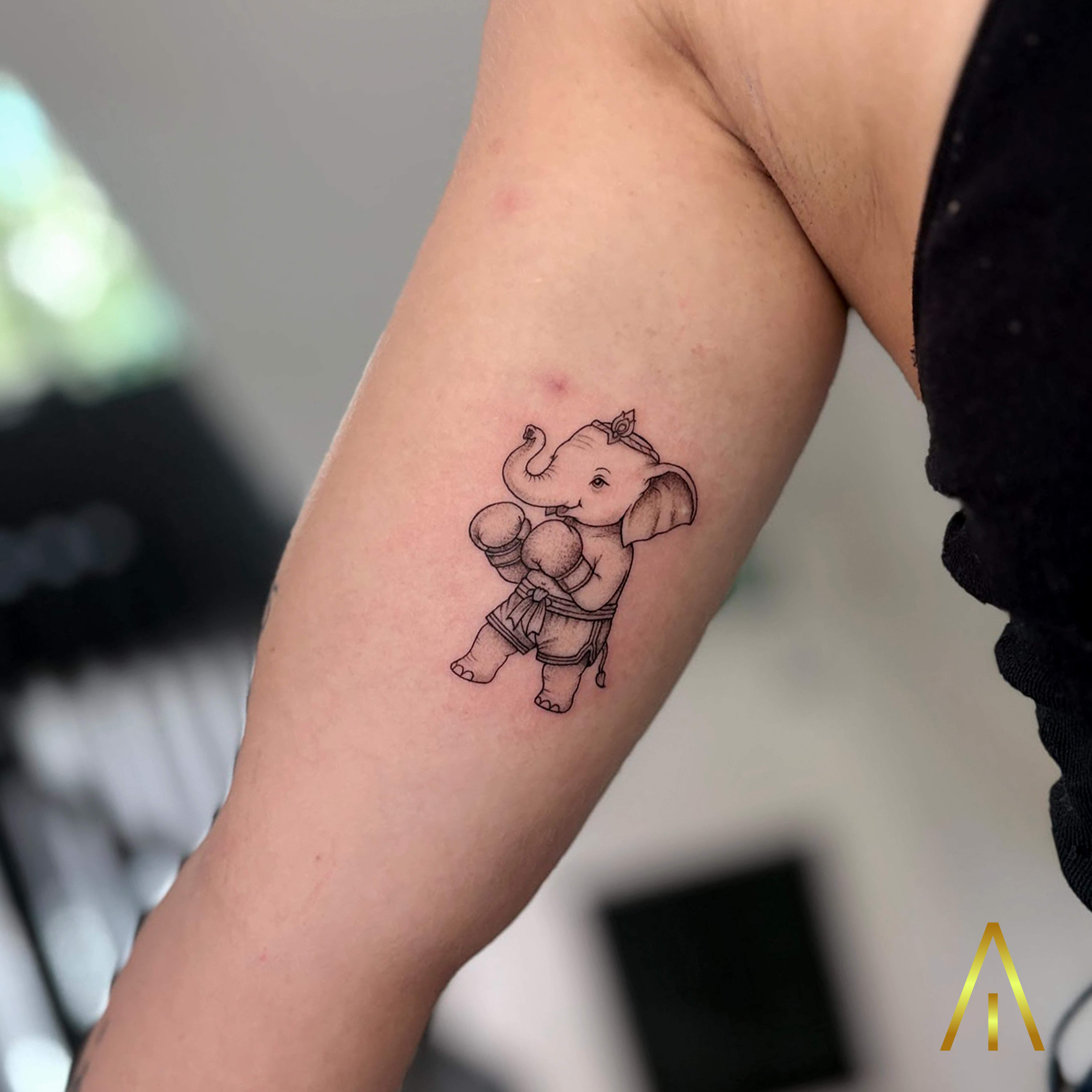 Minimal baby elephant Muay Thai boxer upper arm tattoo Chiang Mai