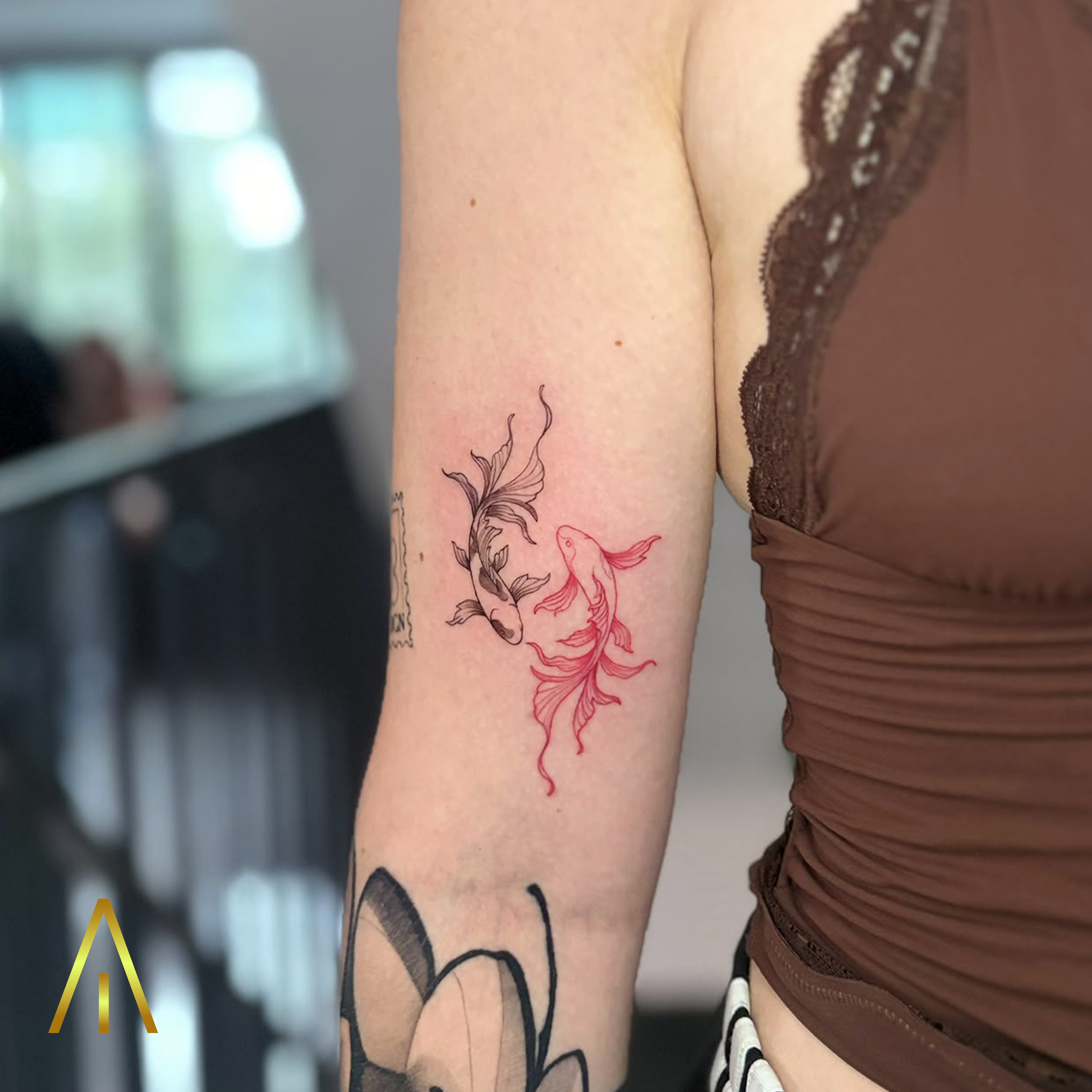 Taely minimal red and black koi fish upper arm tattoo Chiang Mai