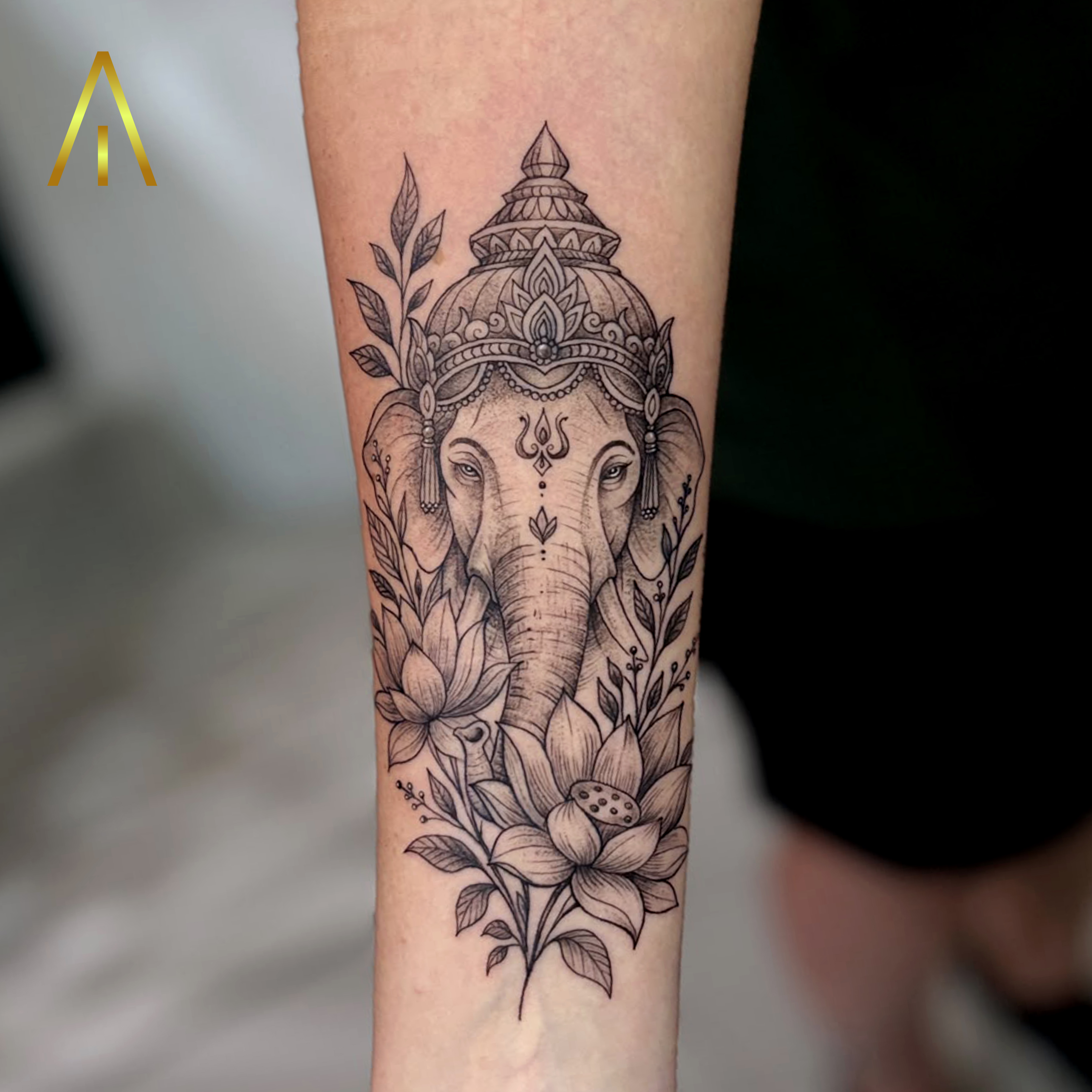 Taely black and grey Ganesha with lotus flowers forearm tattoo Chiang Mai