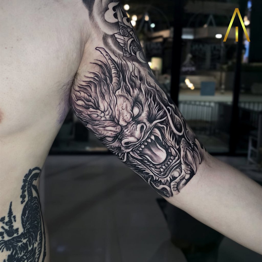 Japanese dragon head black and grey tattoo on upper arm Chiang Mai