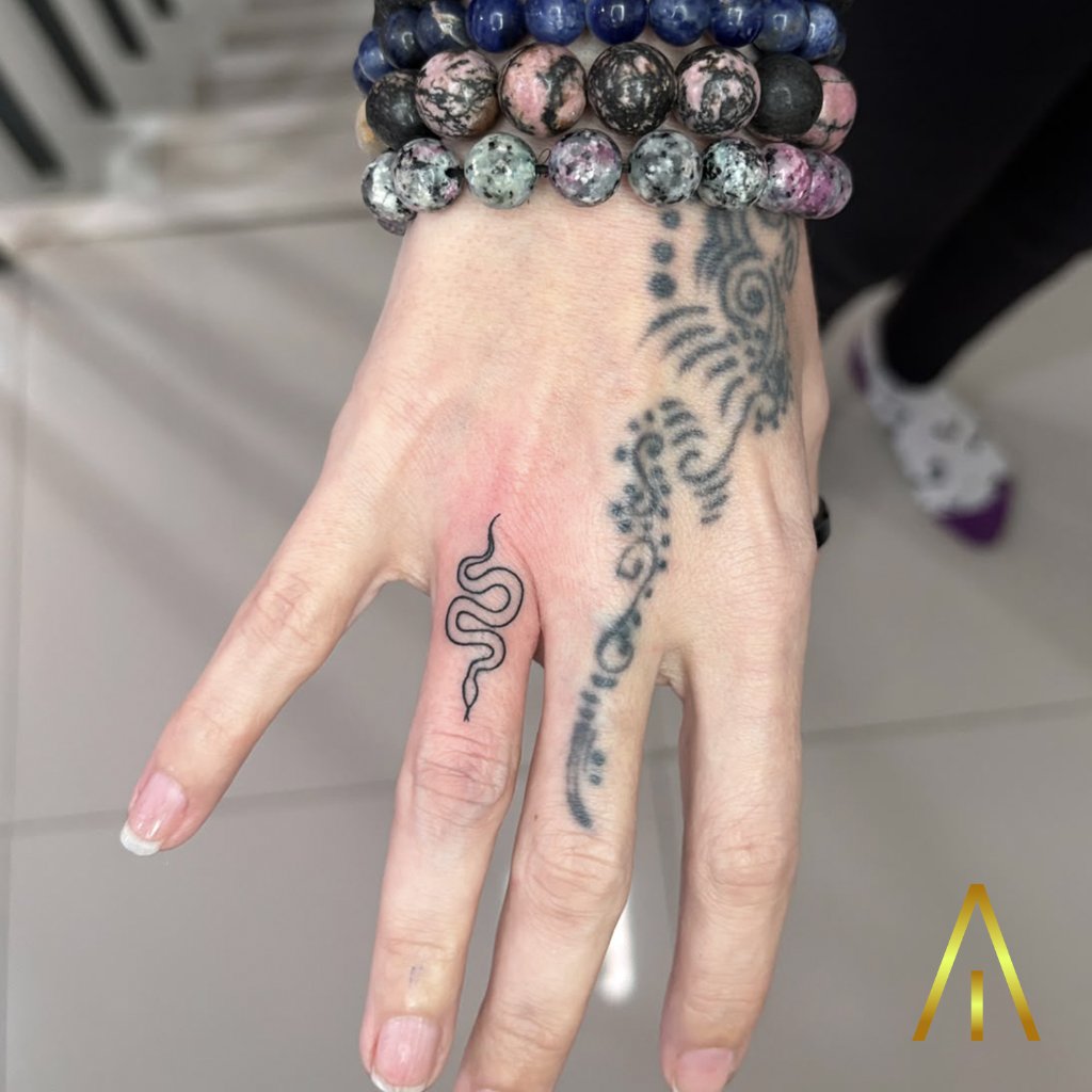 Fine line snake finger tattoo on hand Chiang Mai