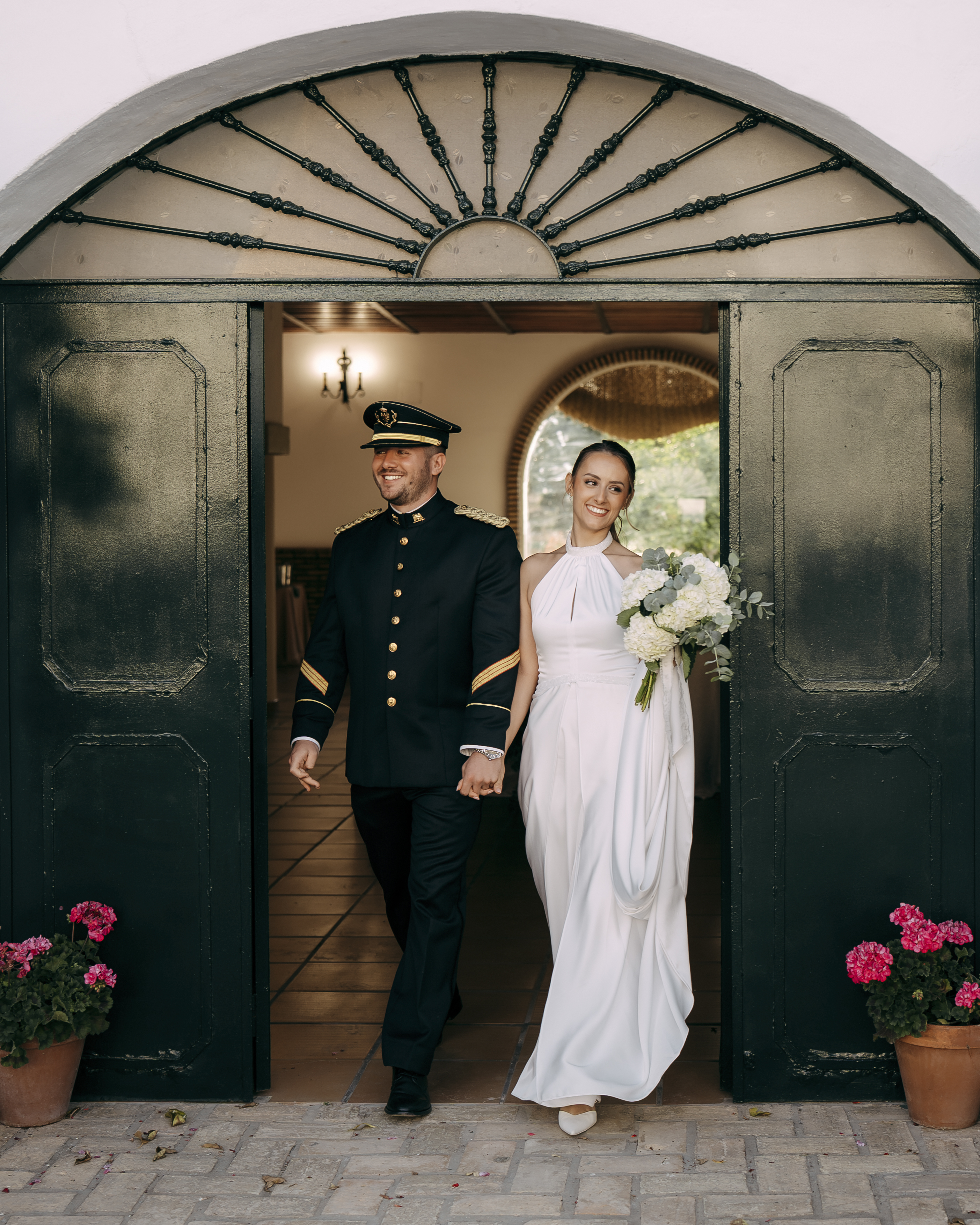 Novios saliendo de la iglesia por una puerta arqueada
