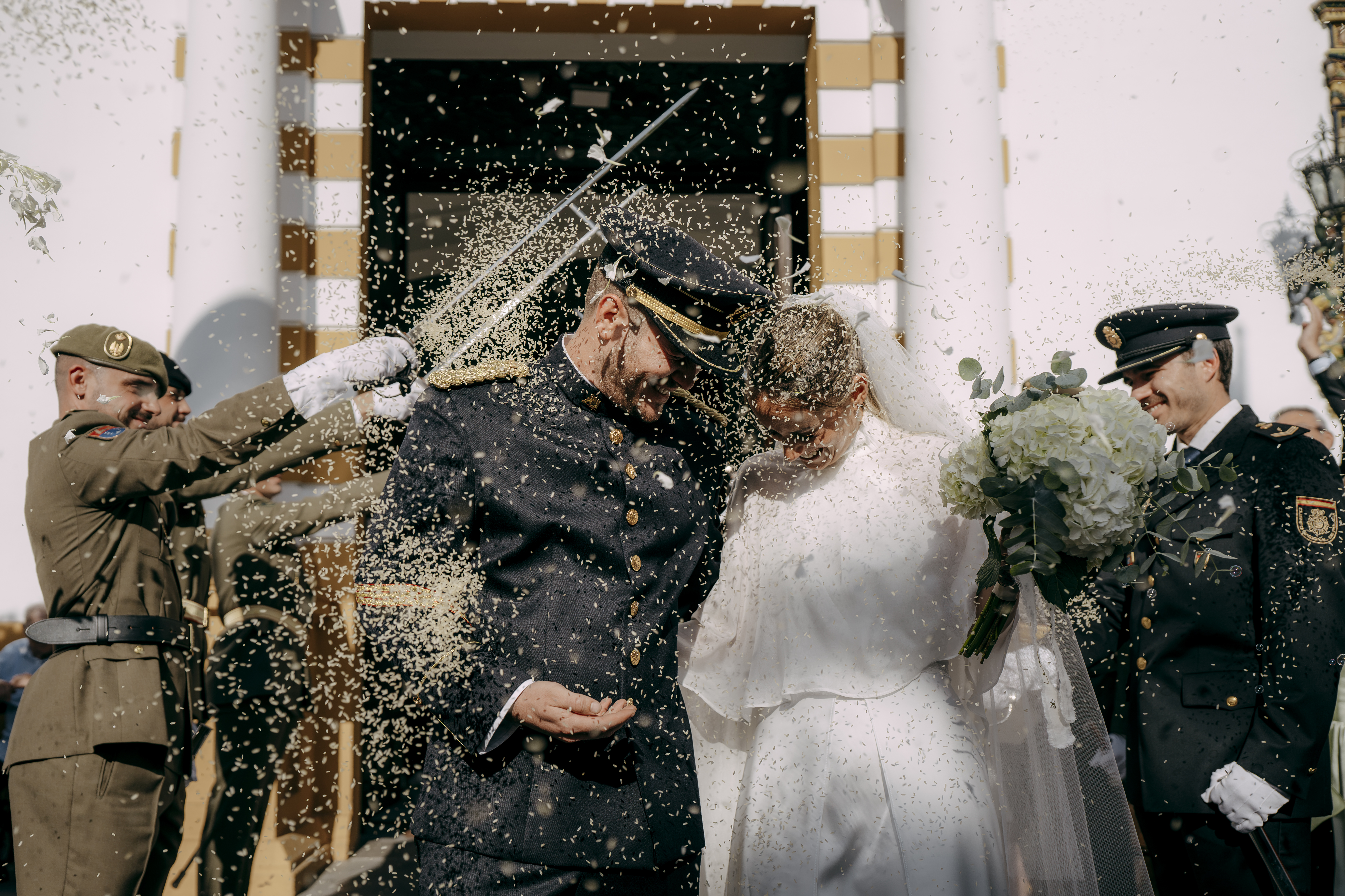 Salida de los novios de la iglesia entre arcos de espadas y arroz