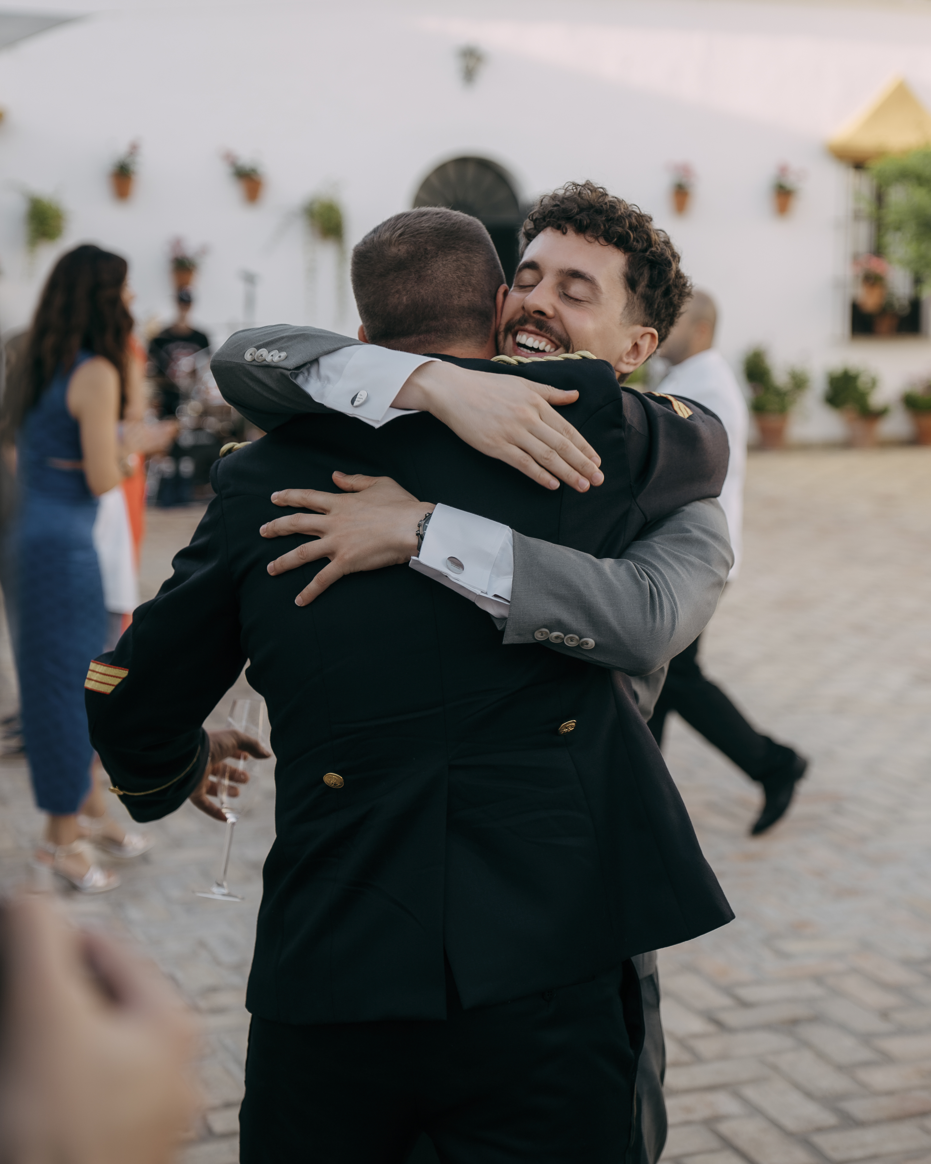 Abrazo emocionado entre el novio y un invitado durante la boda