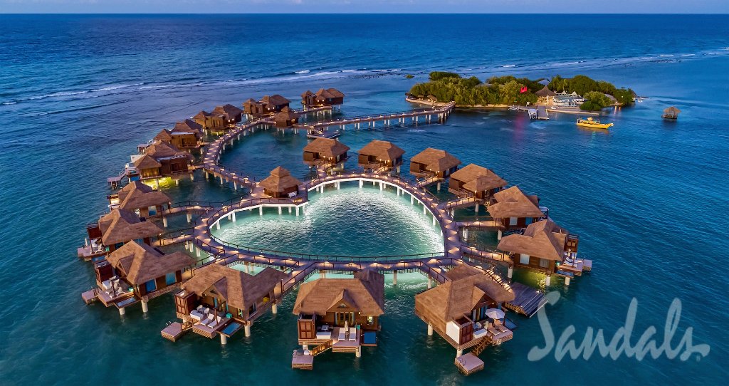 Sandals Resort heart-shaped overwater bungalow village at dusk