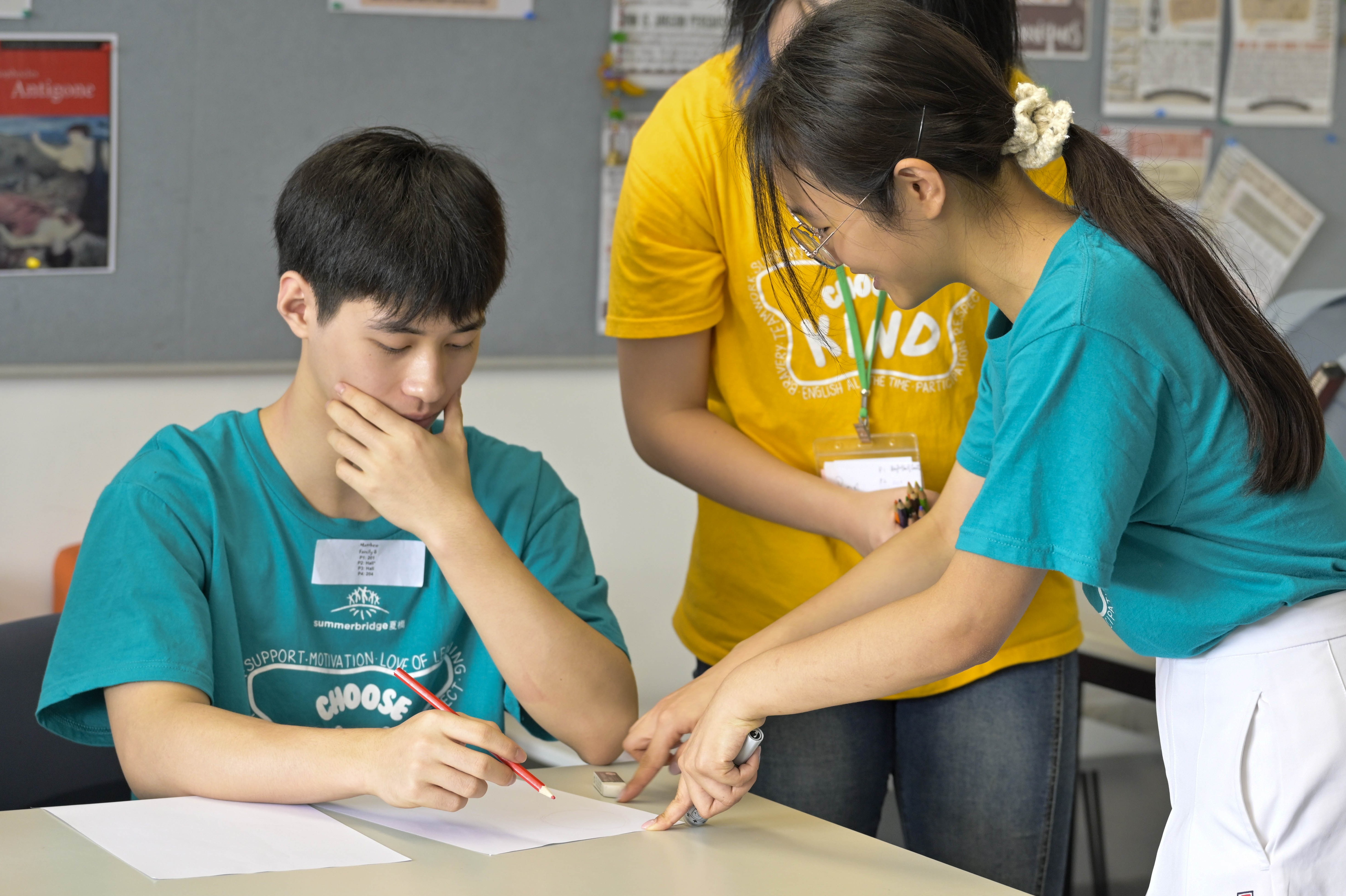 Students collaborating on classwork at a desk