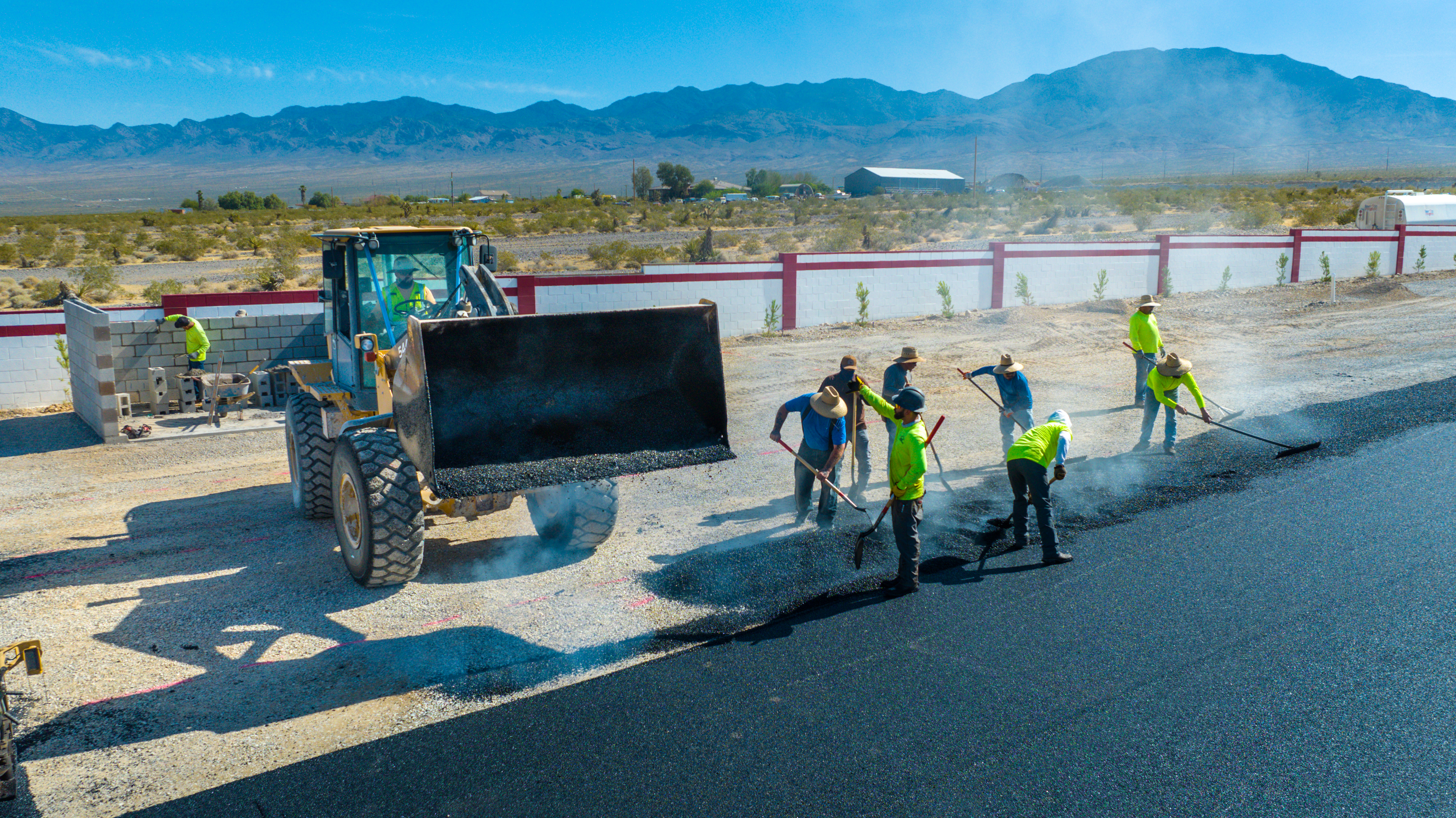 Crew smoothing fresh asphalt