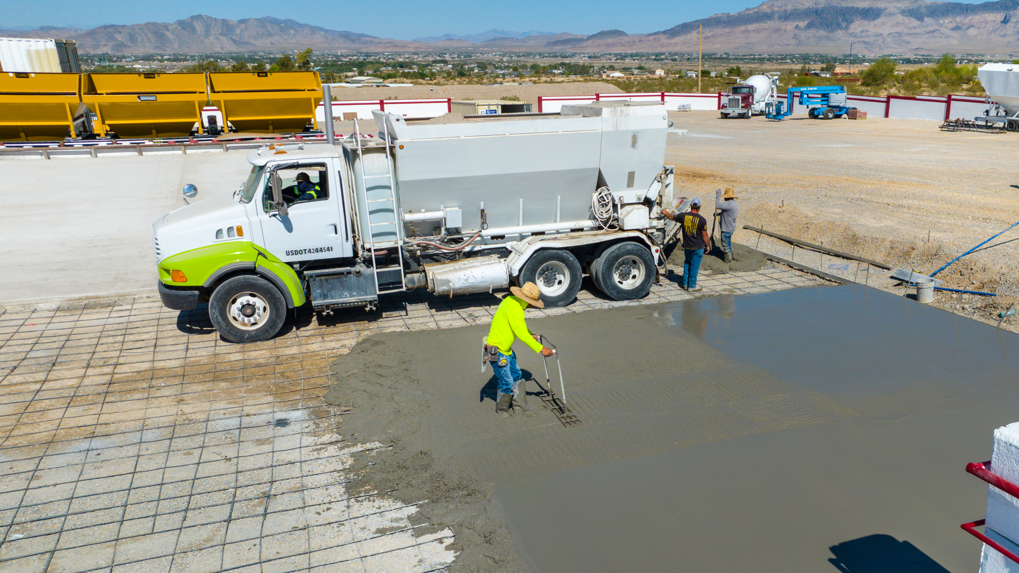 Worker raking fresh concrete