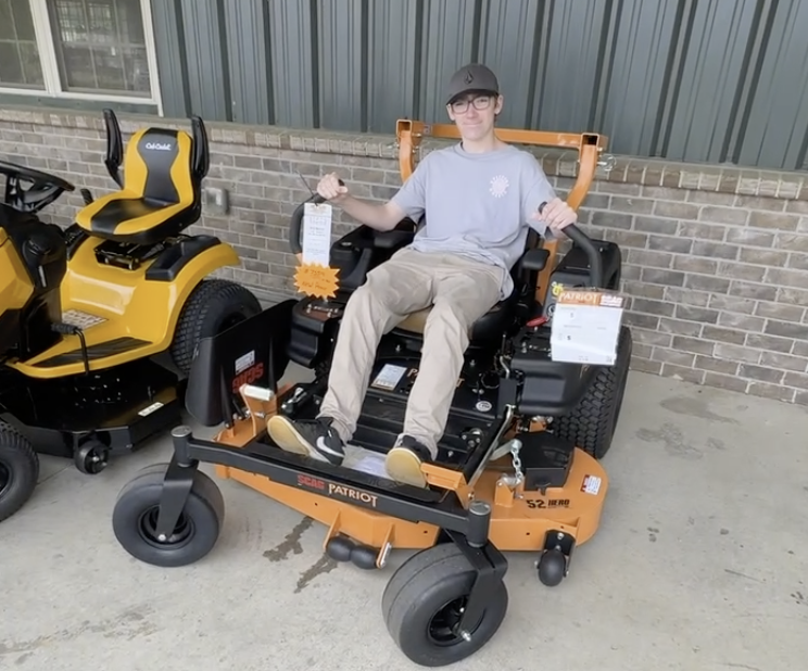 Cameron Manly, a 14-year-old lawn care entrepreneur in Canton GA, sitting on a lawn mower